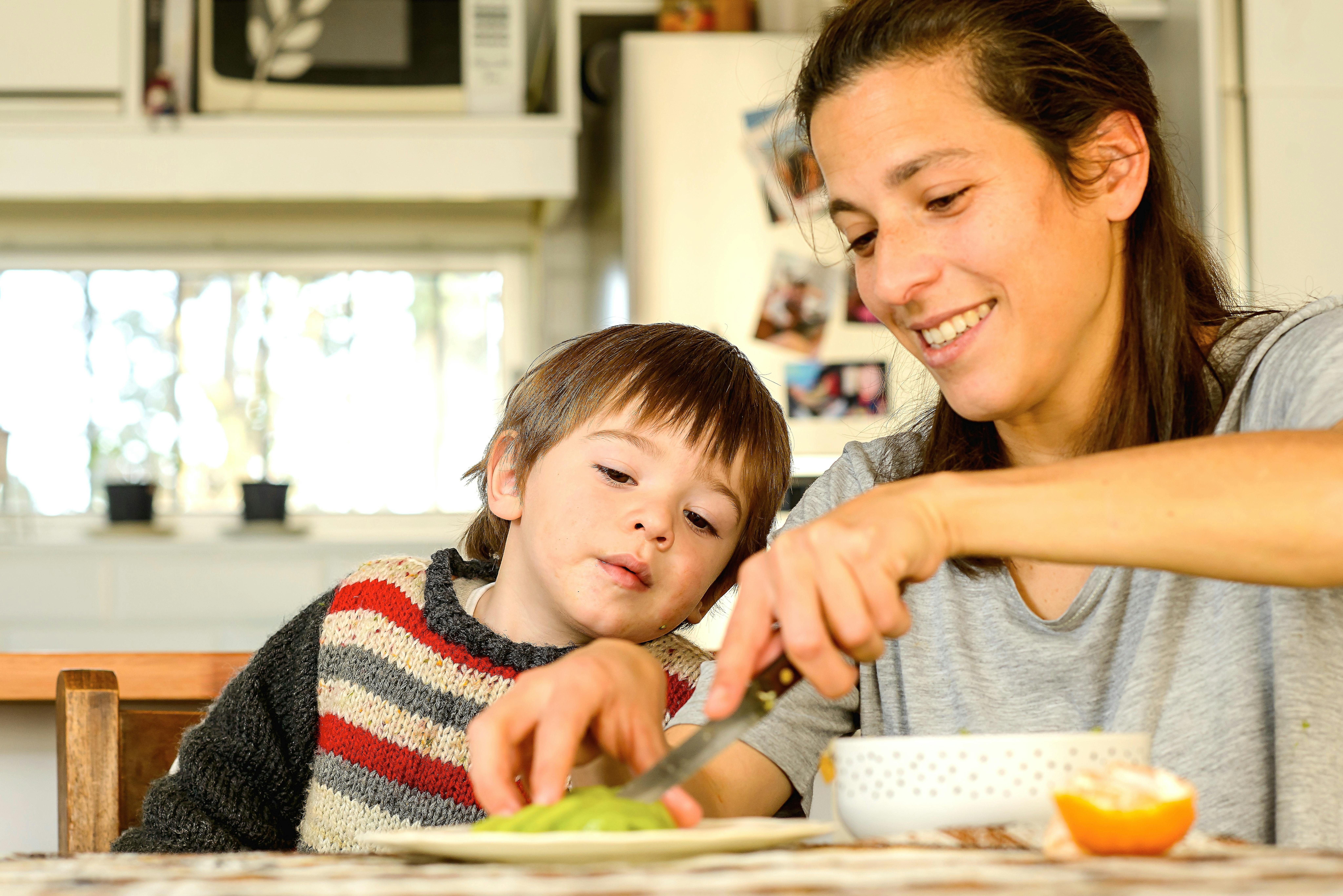 Joaquín, 2 anni, osserva mentre sua madre Rosina taglia il kiwi per il dessert, dopo aver pranzato nella loro casa in una zona rurale del dipartimento di San José, in Uruguay