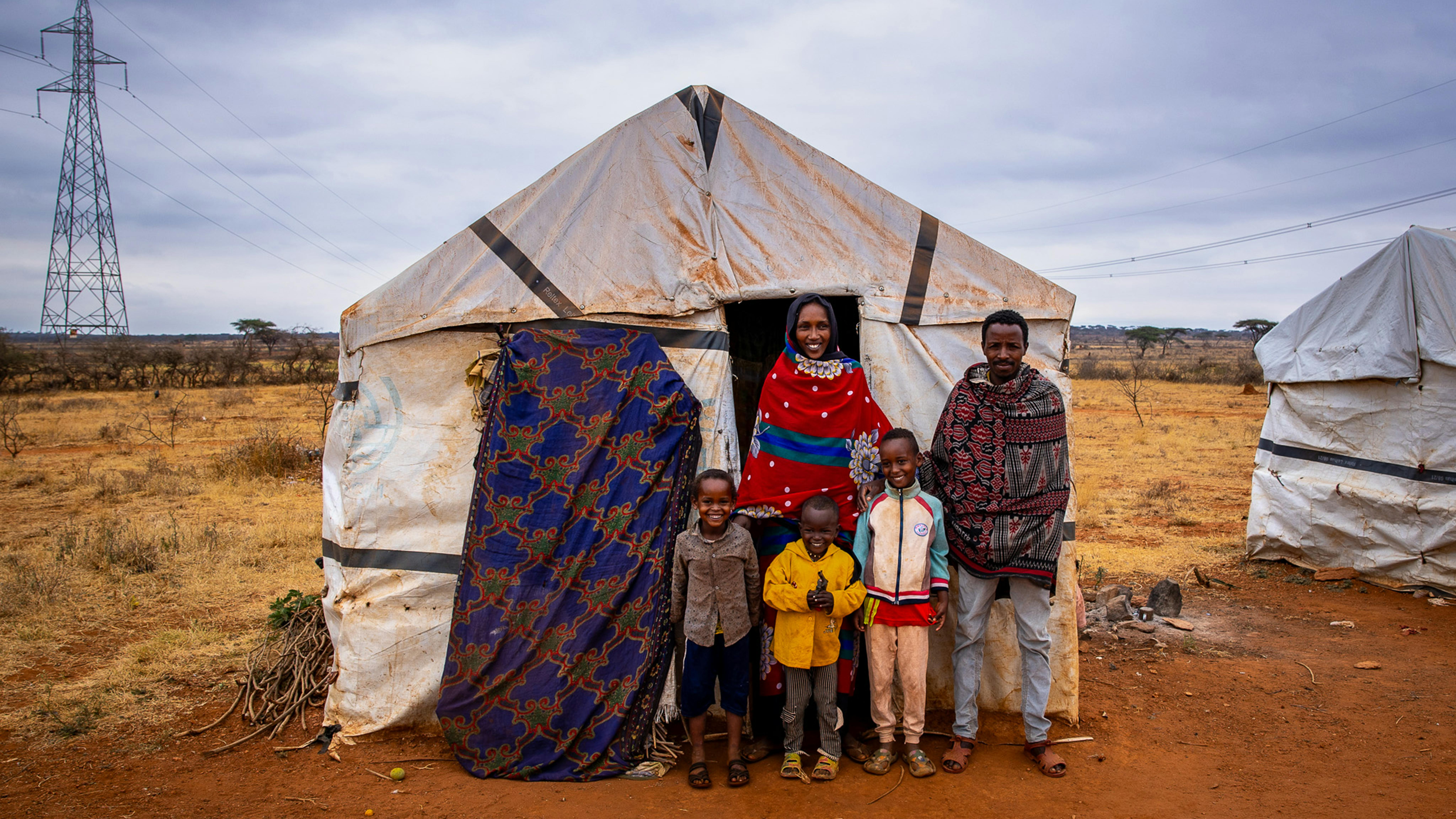 Derara, 7 anni (a sinistra), con la sua famiglia davanti al rifugio temporaneo nel campo per sfollati interni di Dubuluk