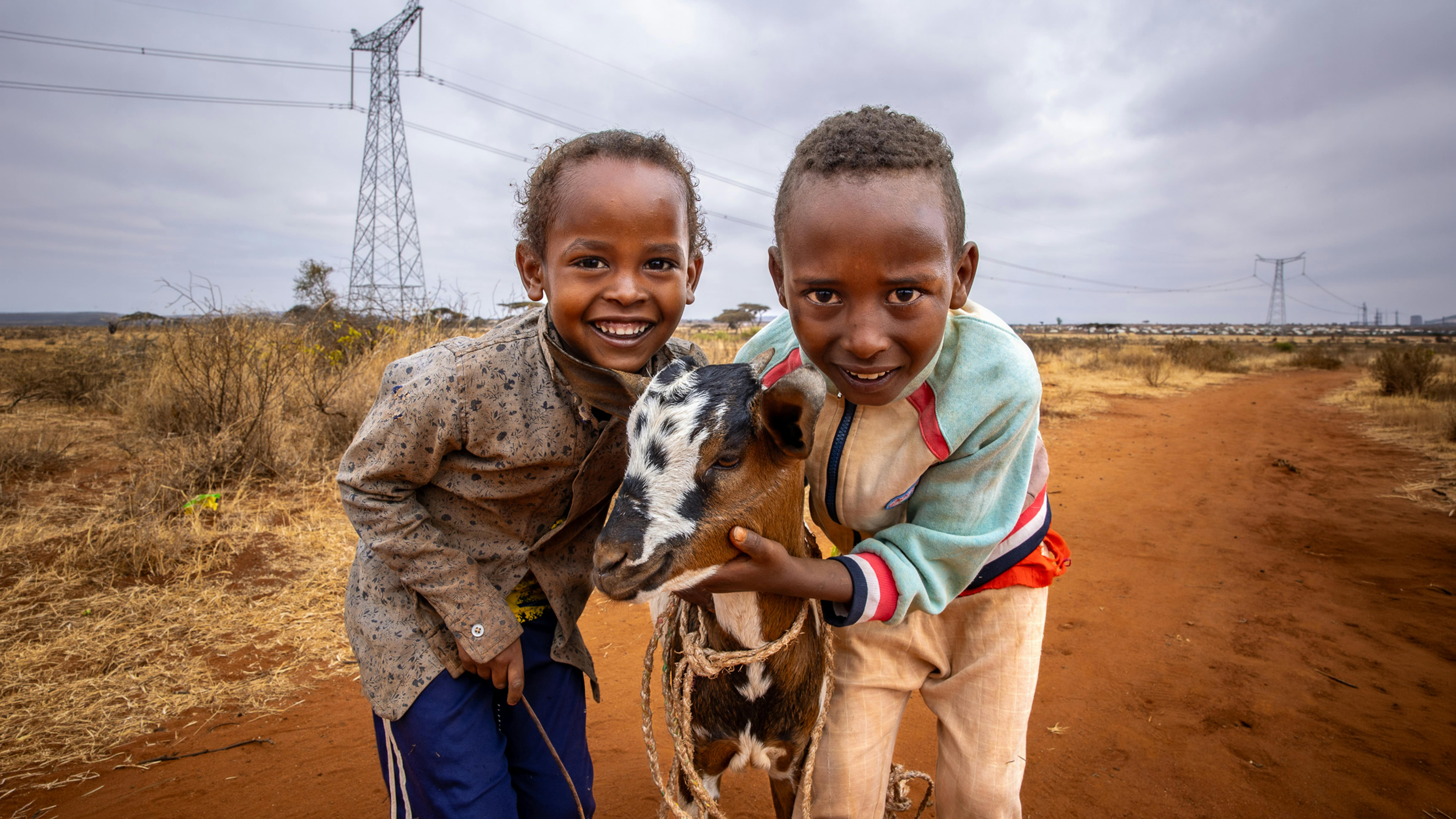 Dubuluk, Etiopia. Derara, 7 anni e suo fratello maggiore portano al pascolo la capra acquistata dalla famiglia grazie al sostegno in denaro dell’UNICEF, un aiuto concreto per rafforzare resilienza e mezzi di sussistenza