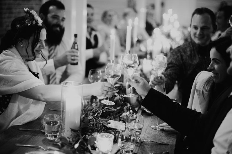 Black and white image of guests raising a toast