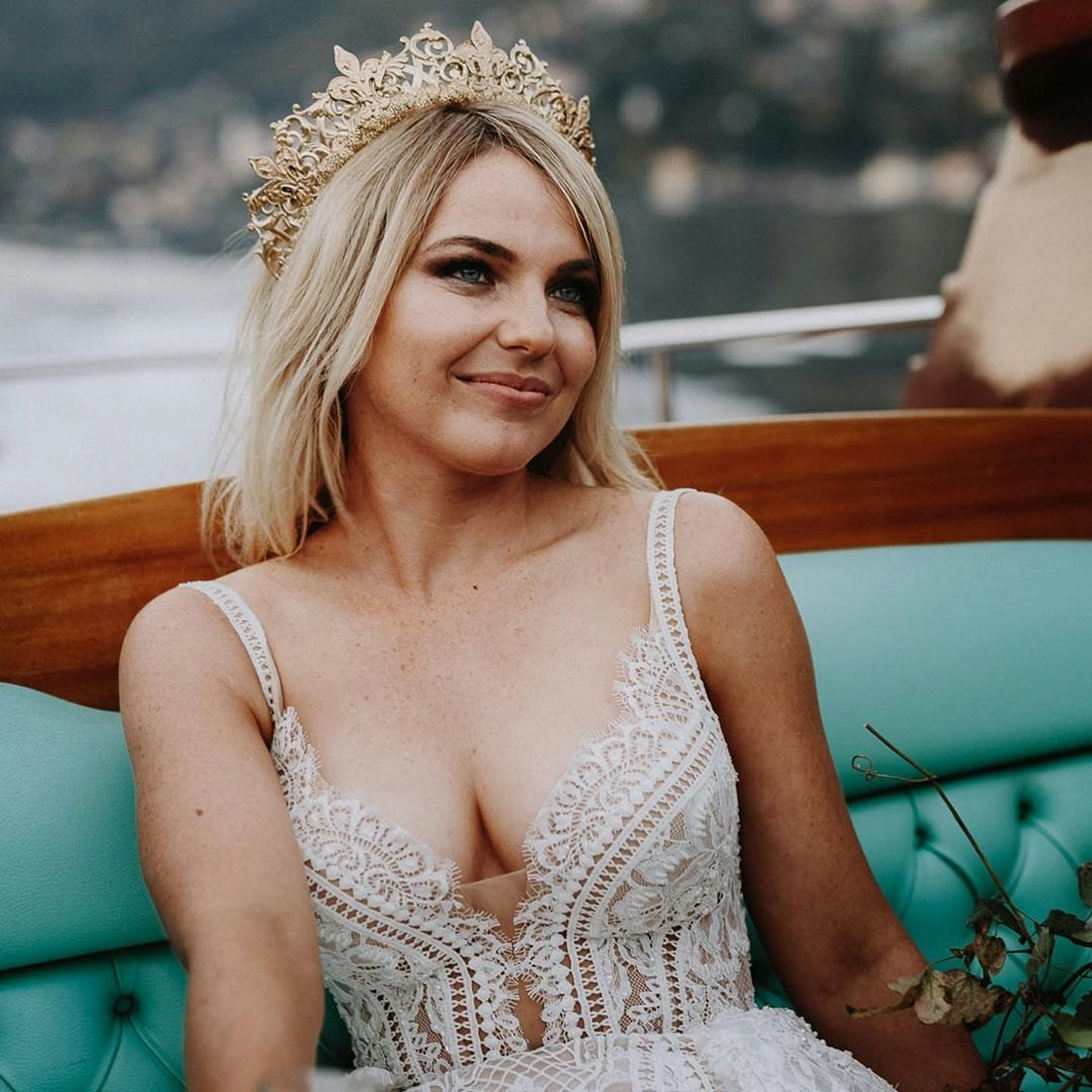 Bride sitting in a boat wearing a gold crown 