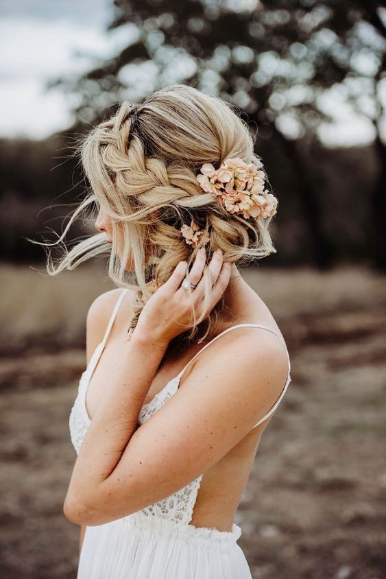 Bride with loosely braided hair with flowers in it 