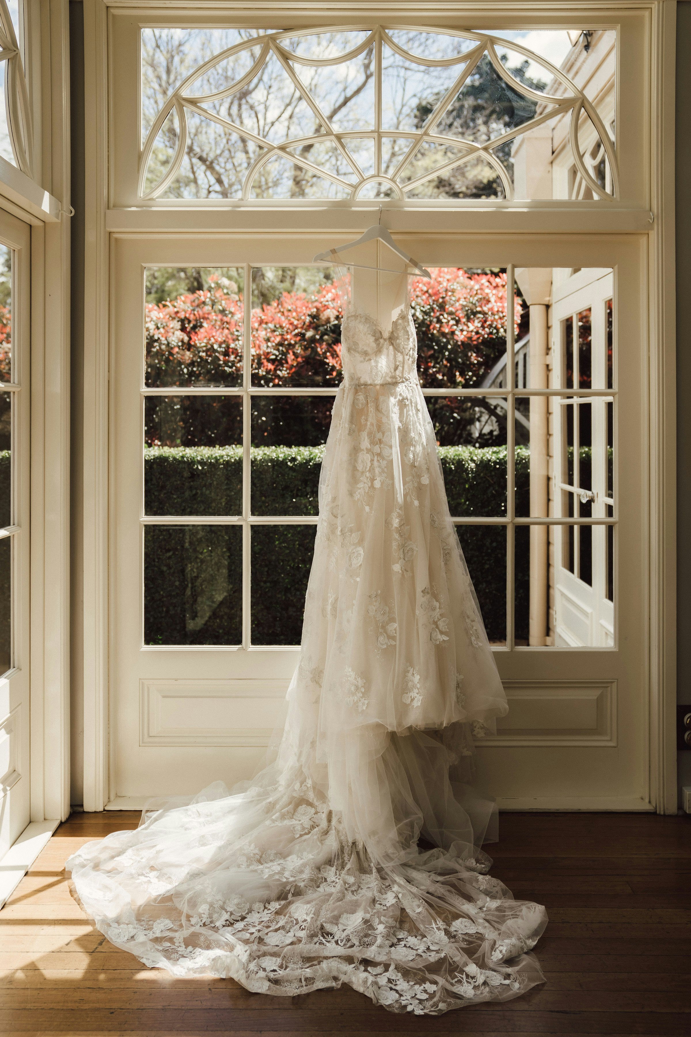 Wedding dress hanging in front of French Doors 
