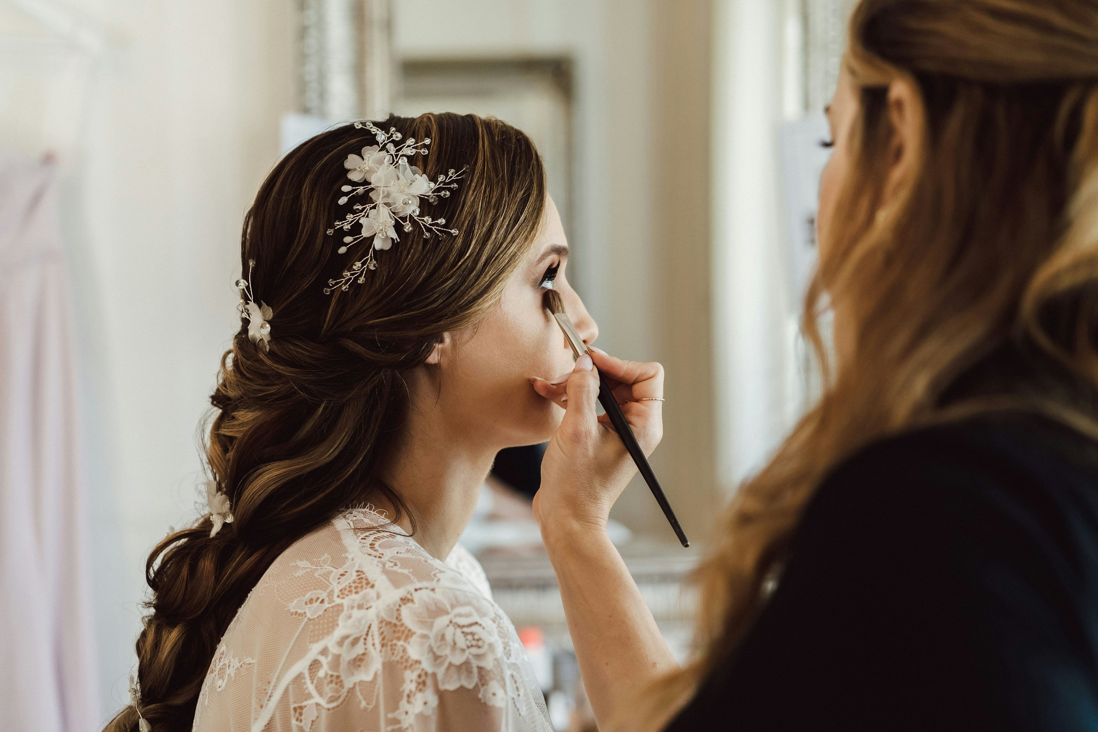 Bride getting makeup applied to her eyes 