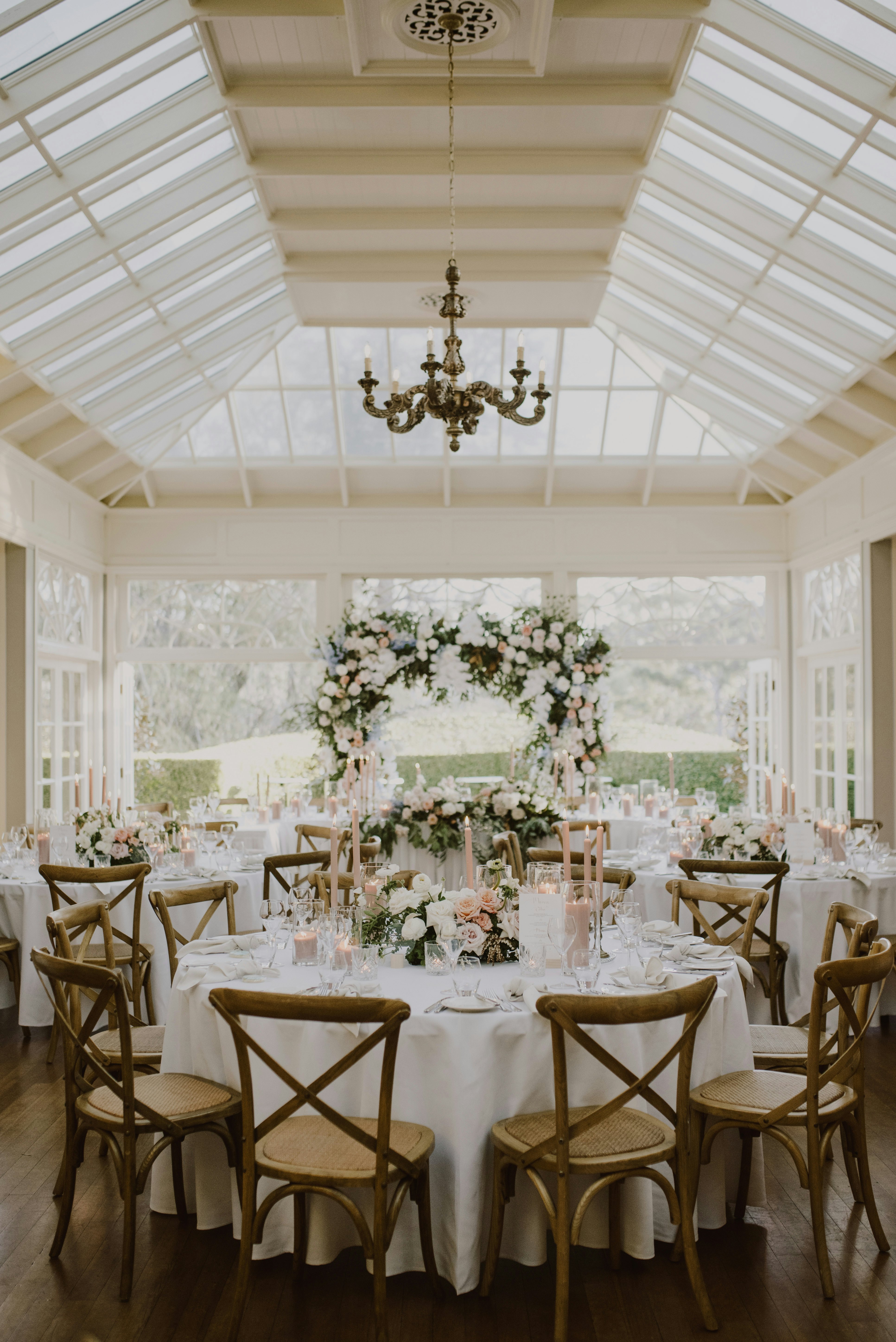 Wedding reception setting with round wooden tables and flowers 