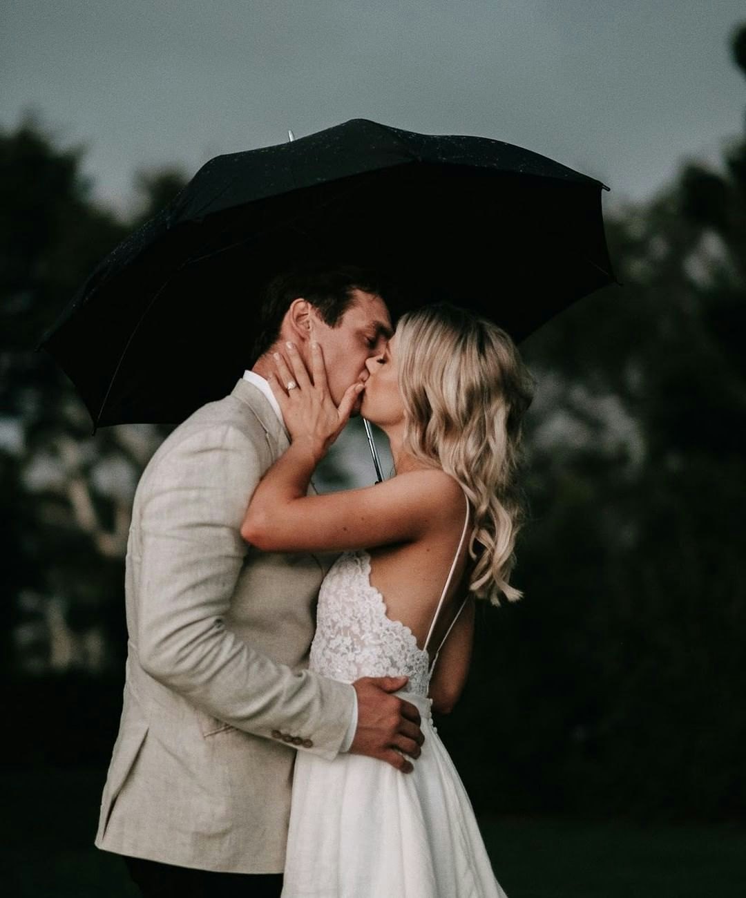 Bride and Groom kissing under umbrella 