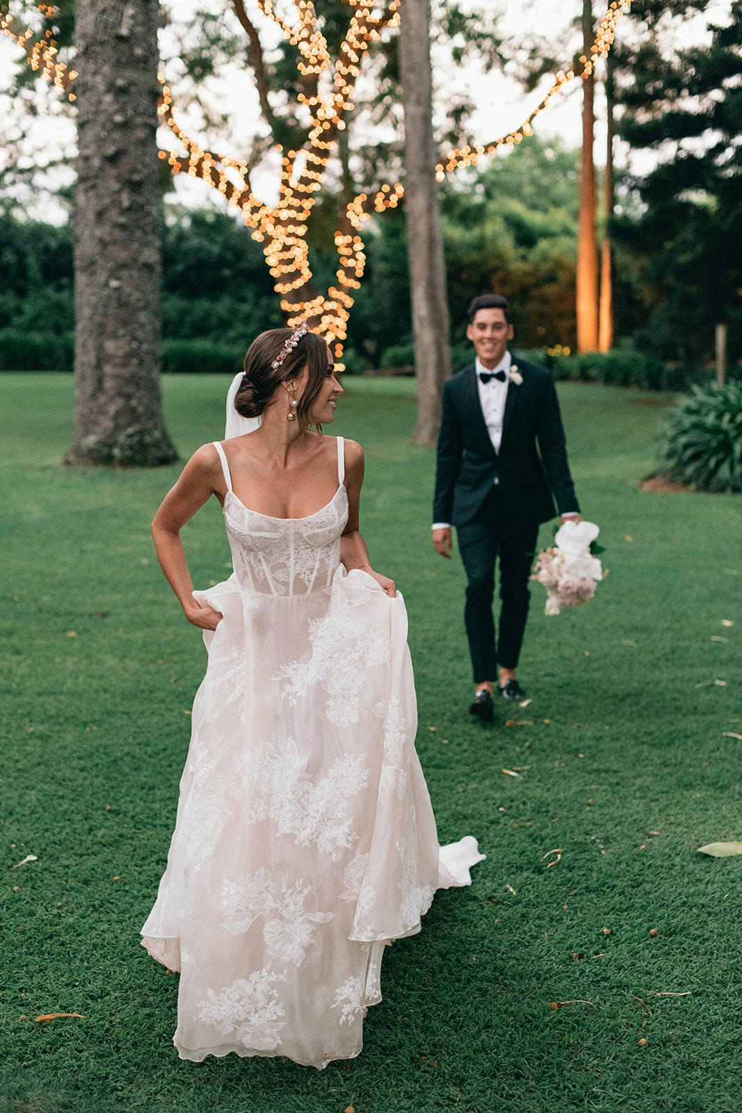 Bride and groom walking through gardens 