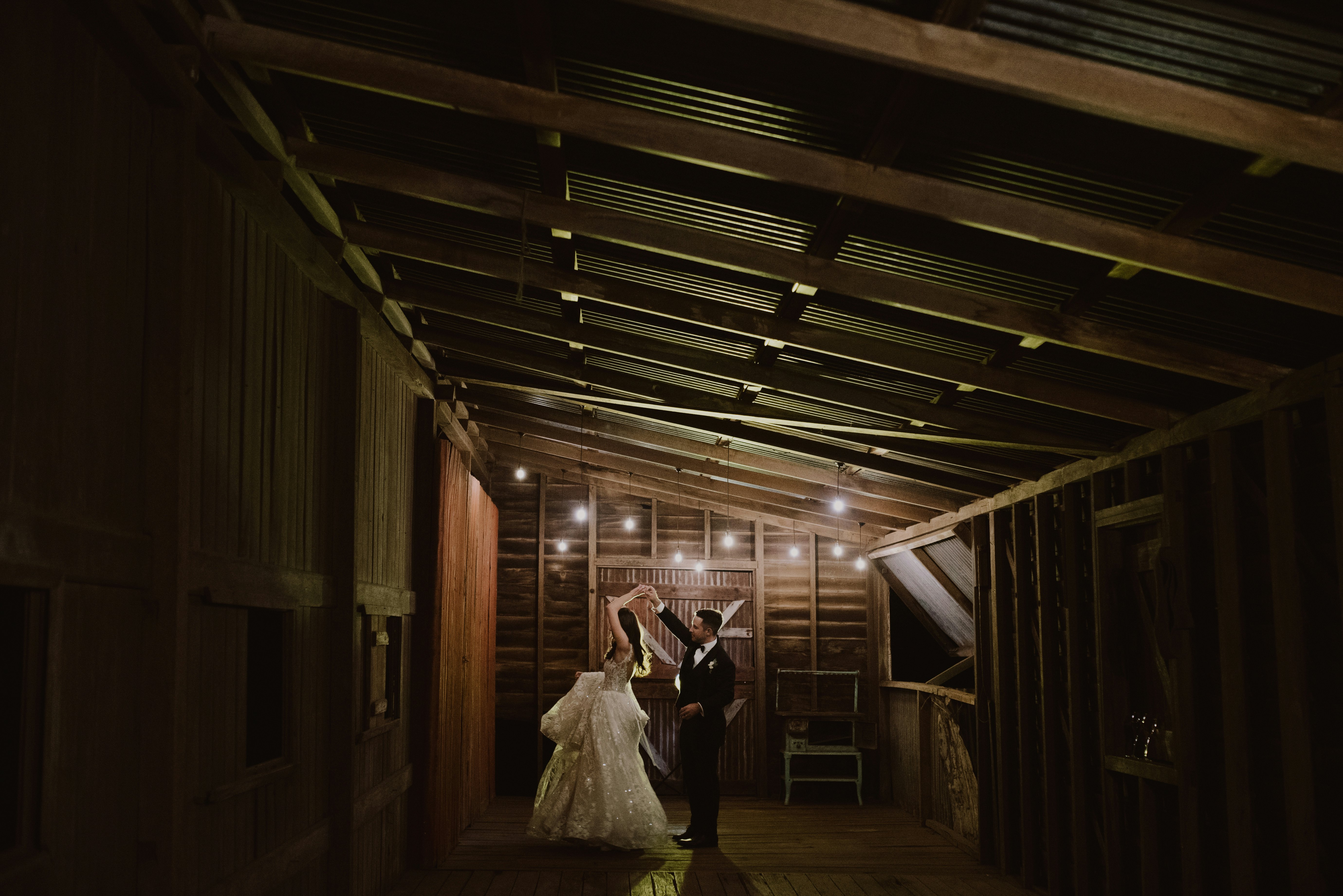 Bride and groom dancing in stables 