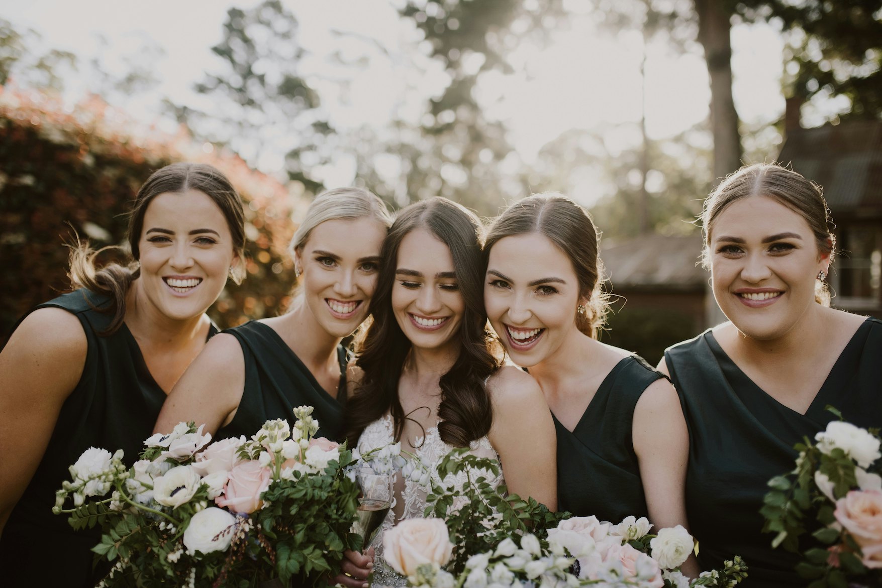Bride and bridesmaids laughing together 