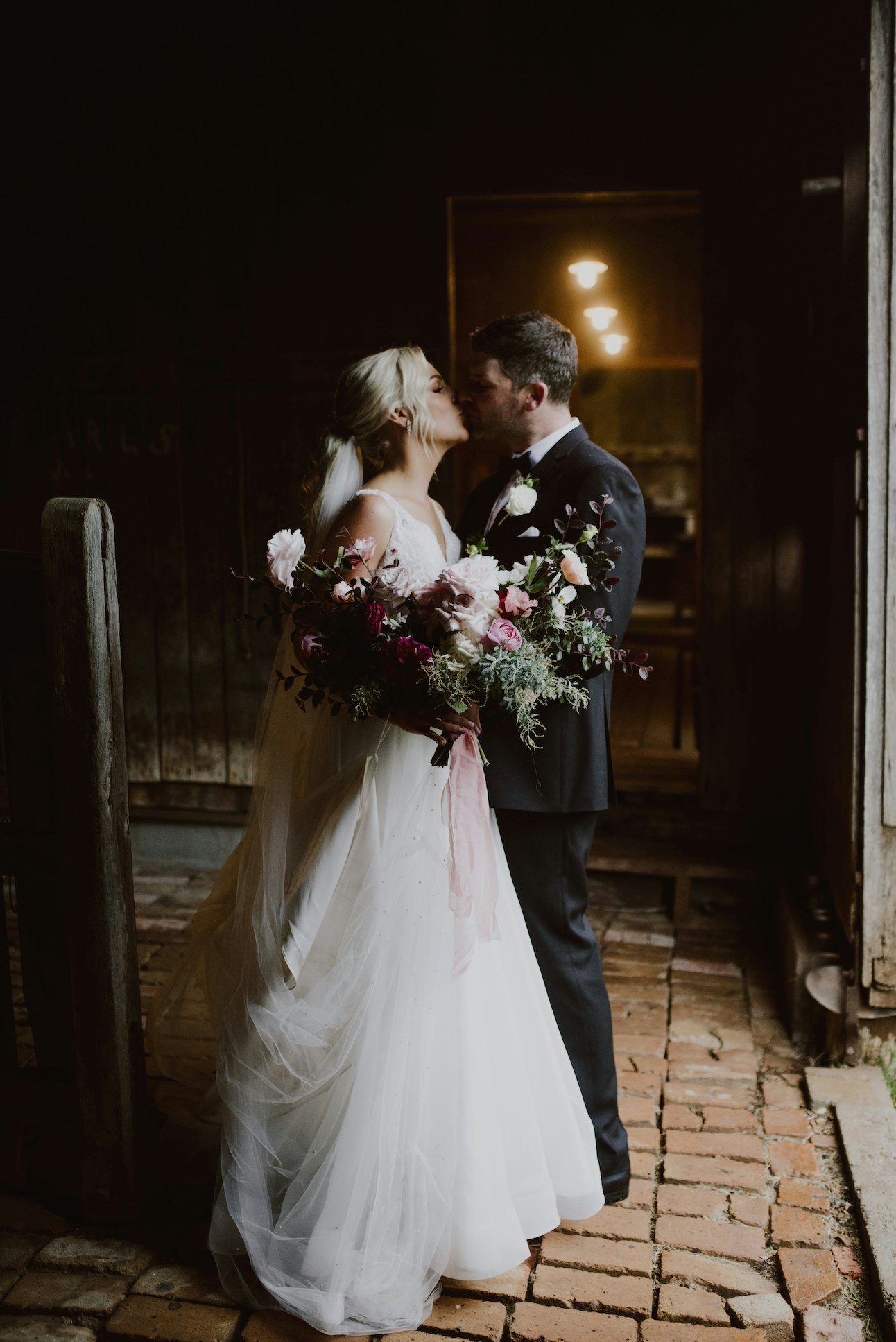 Bride and groom posing together in stables 
