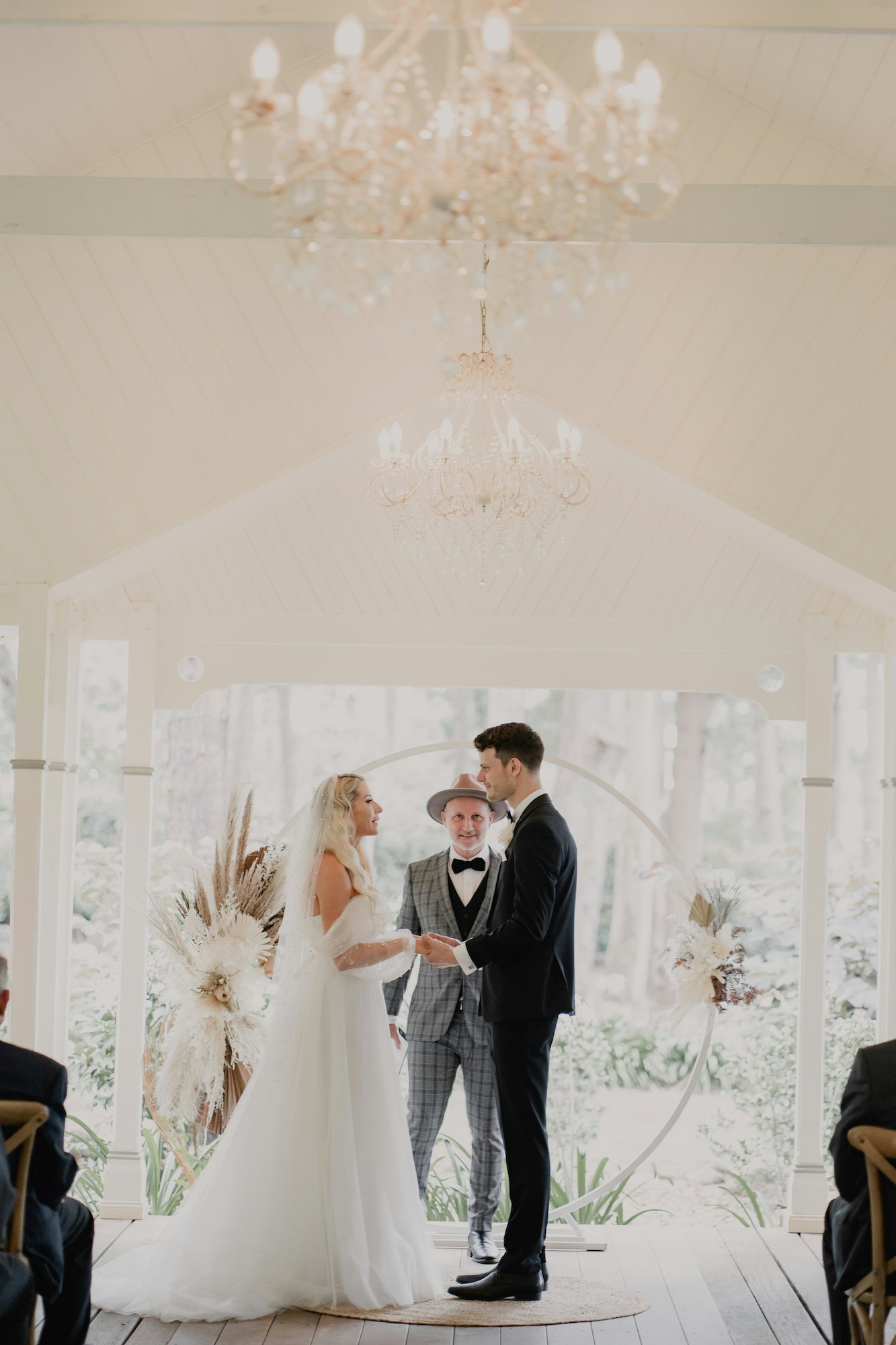 Bride and groom in front of floral arbour 