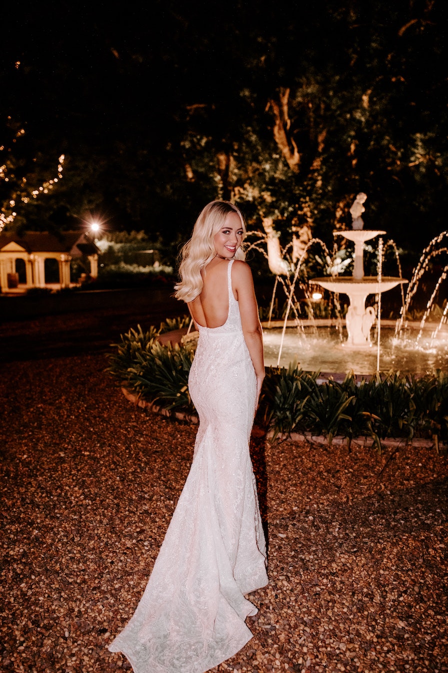 Bride standing in front of fountain at night 