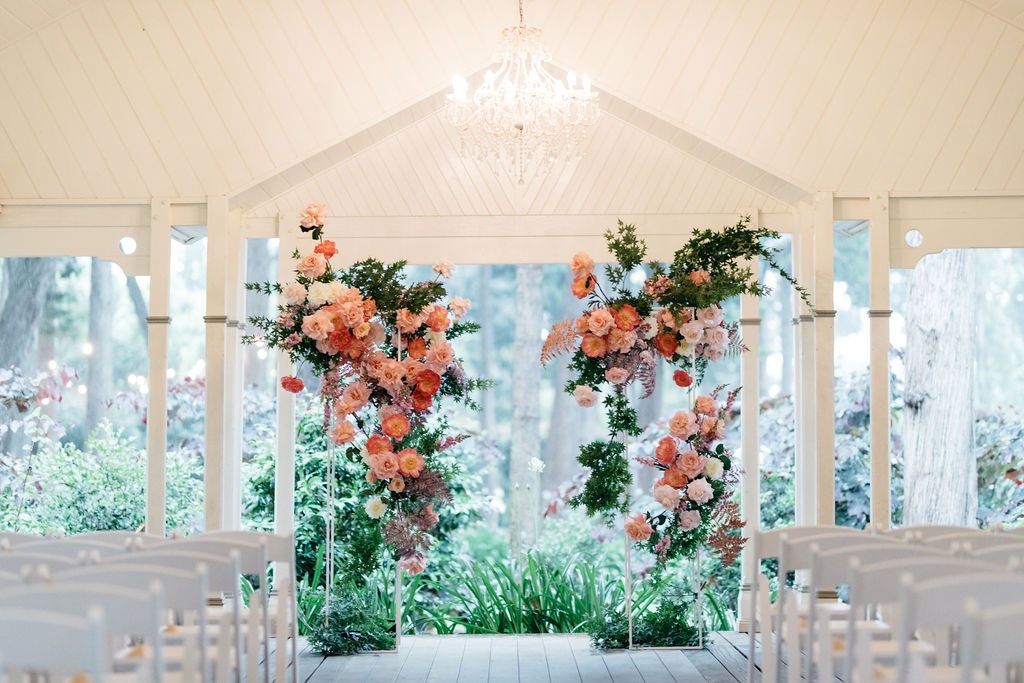 Wedding ceremony with white arbour and colourful flowers 