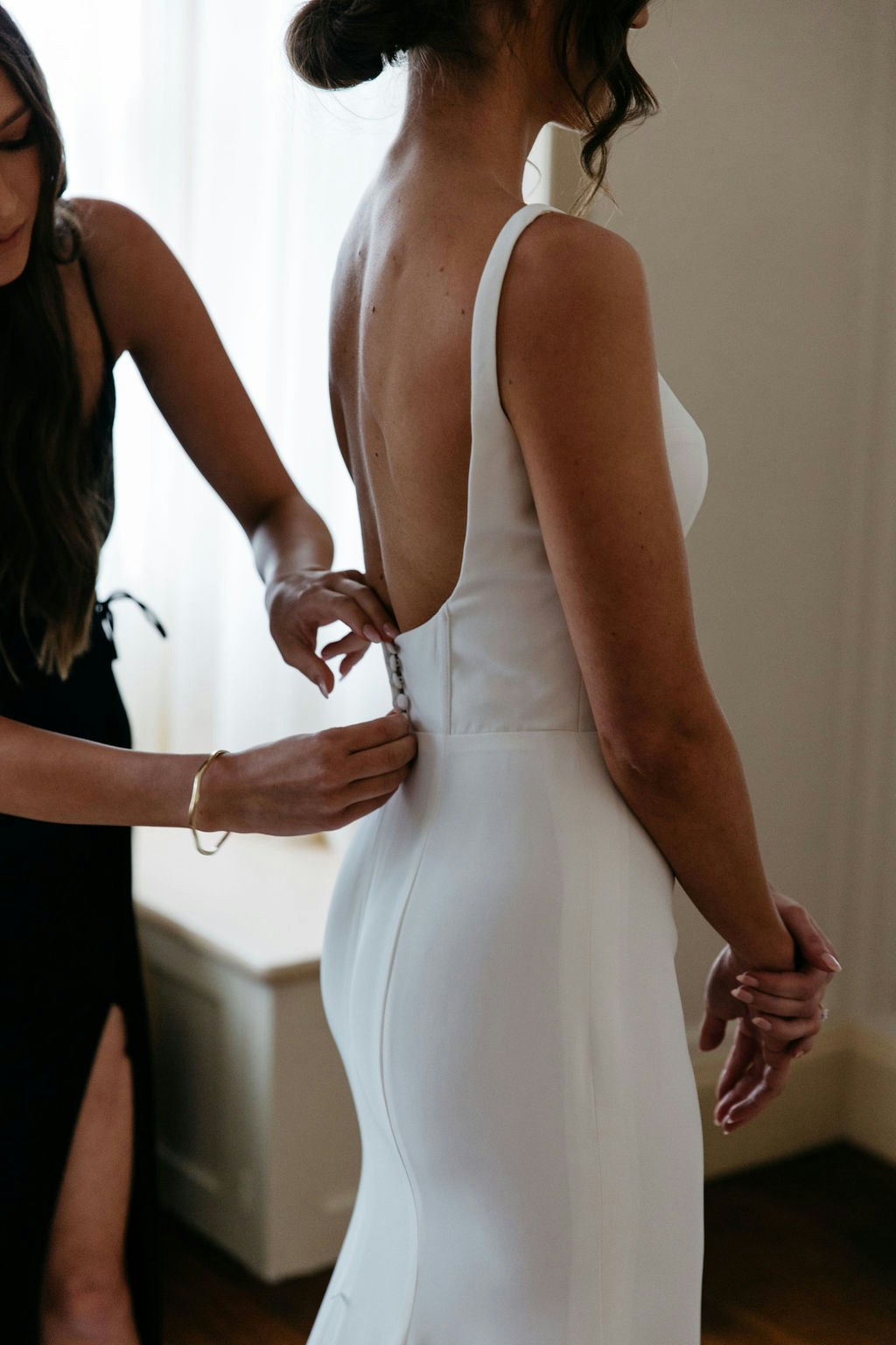 Bride getting dress buttoned up 