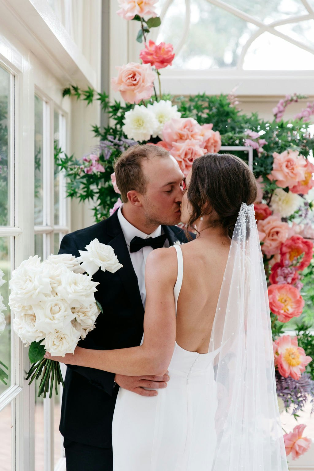 Bride and groom kissing in front of couple