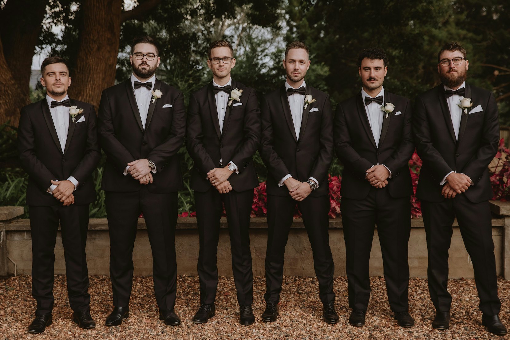 Groom and groomsmen standing in a row 