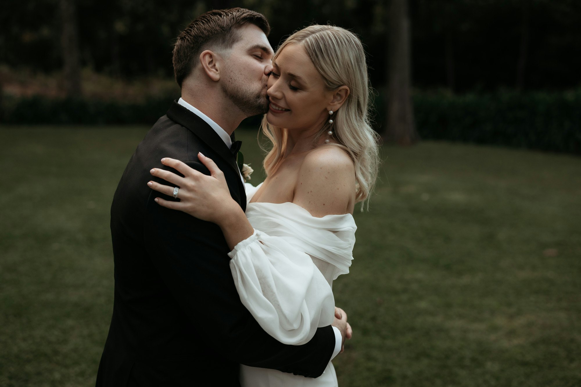 couple embrace and kiss on their wedding day