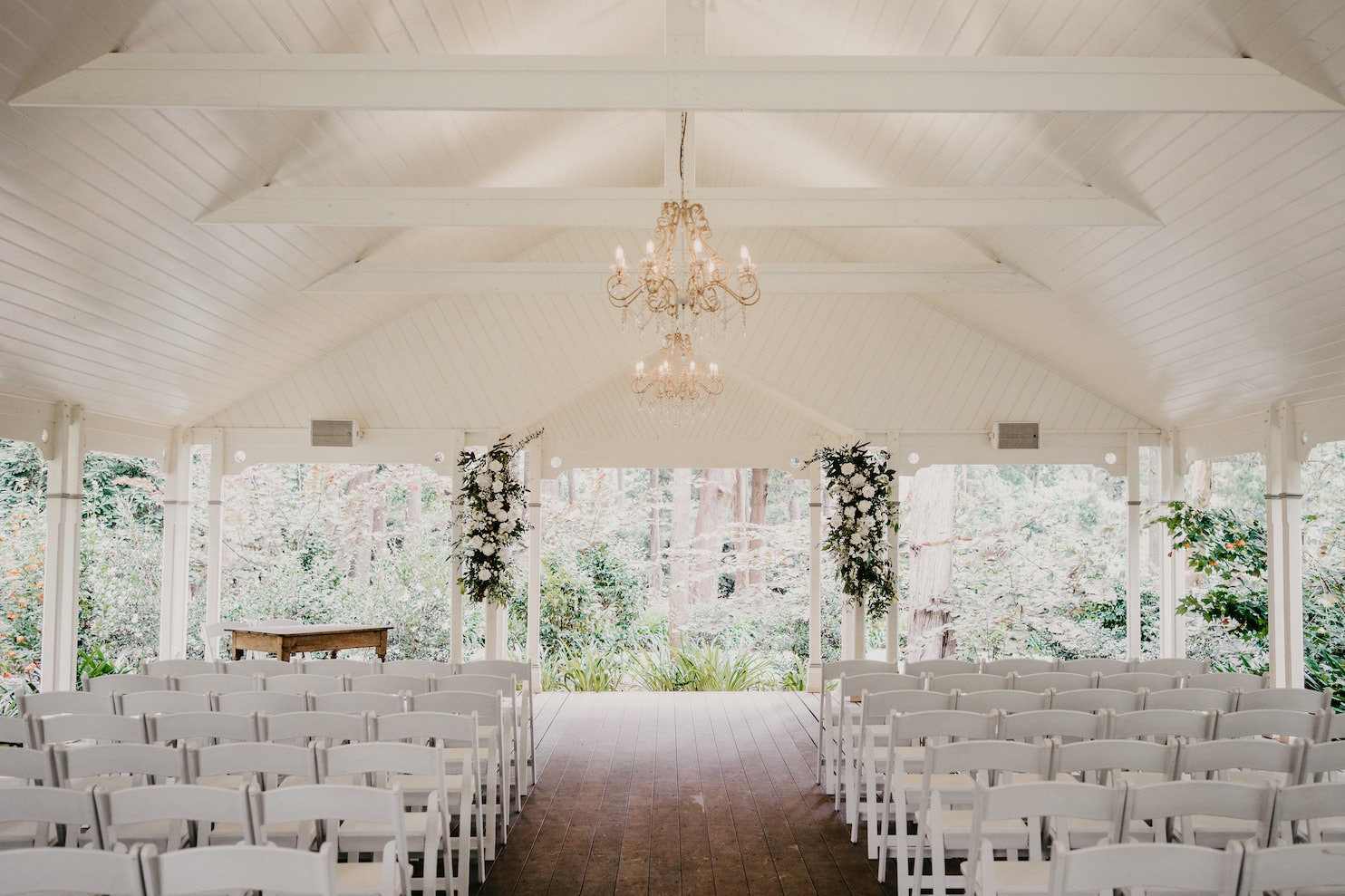 Wedding ceremony with white chairs and arbour