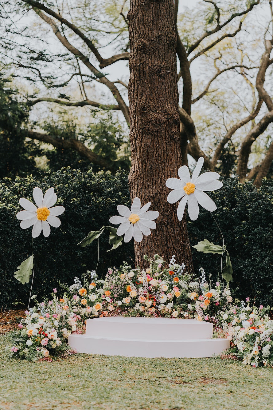 Wedding flowers around stage with giant daisies