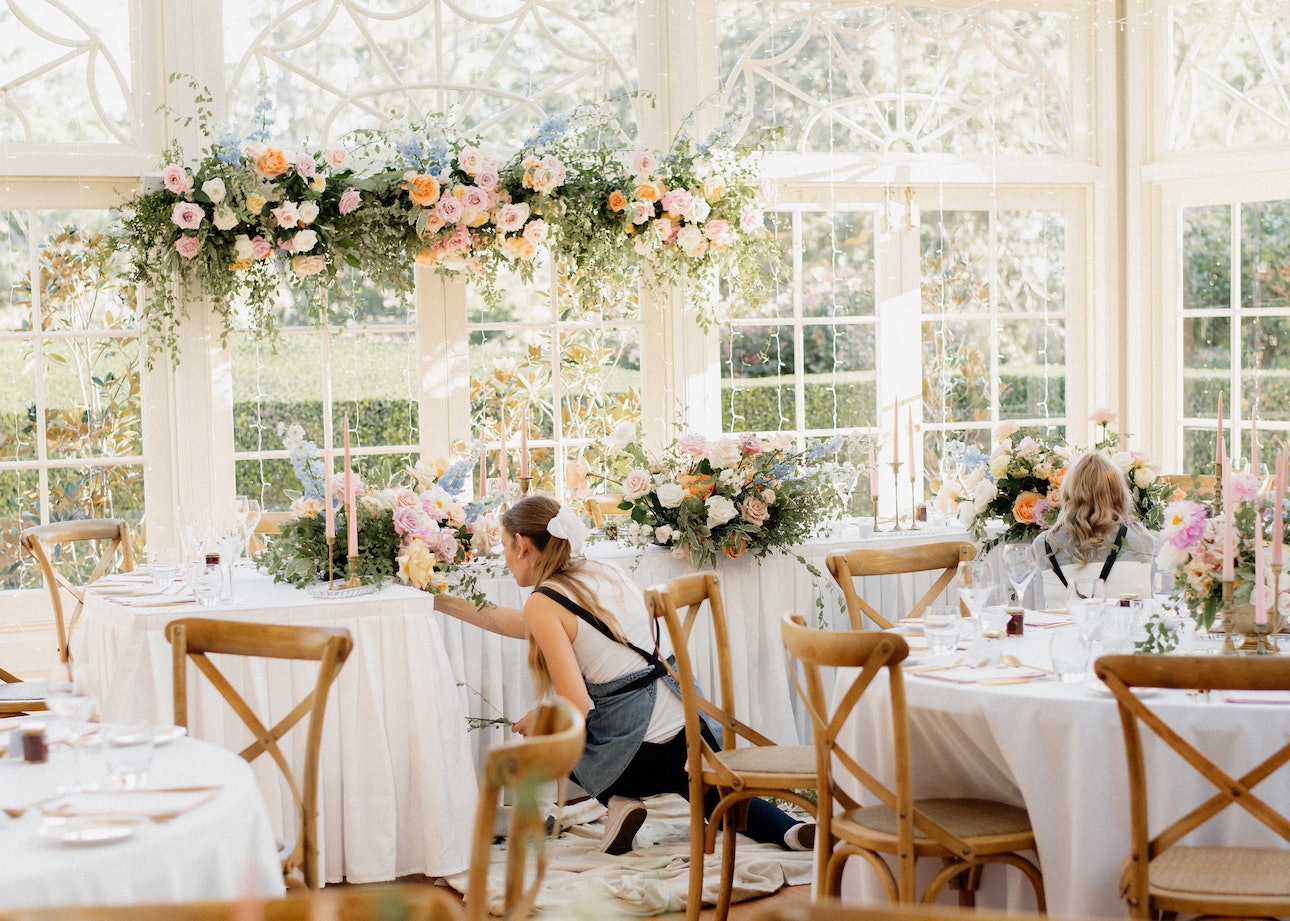 Florist setting wedding table with flowers