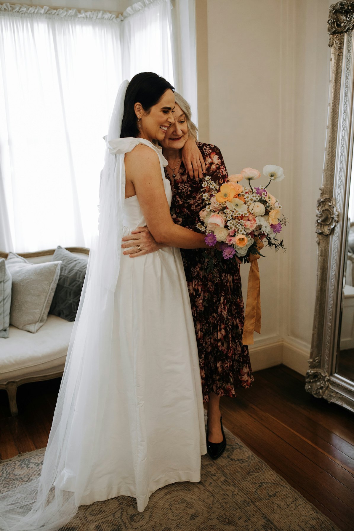 Bride and mother of bride hugging