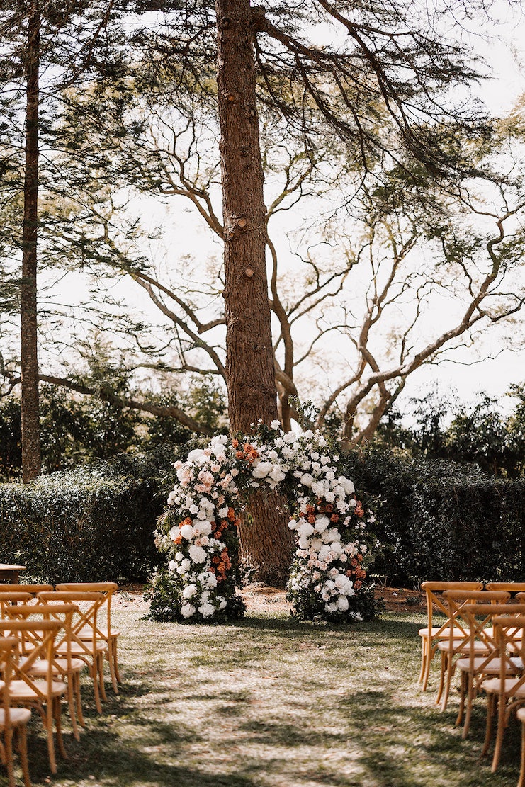 Floral wedding arbour set in front of big tree