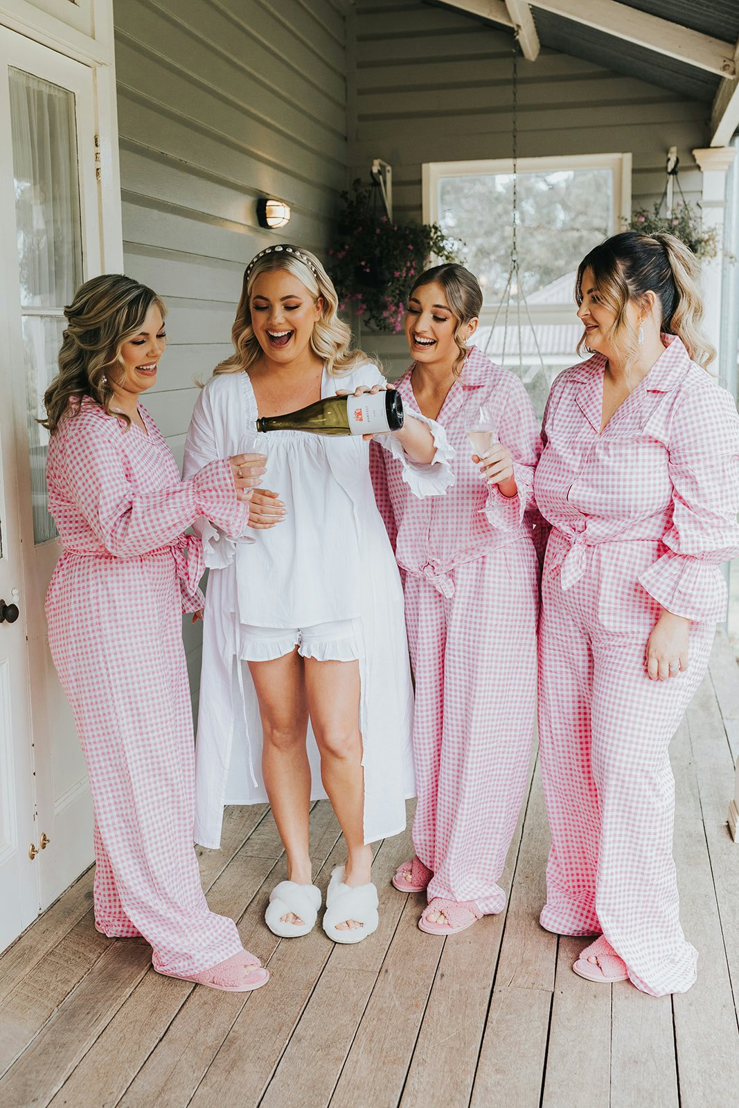 Bride and bridesmaids drinking champagne in pyjamas