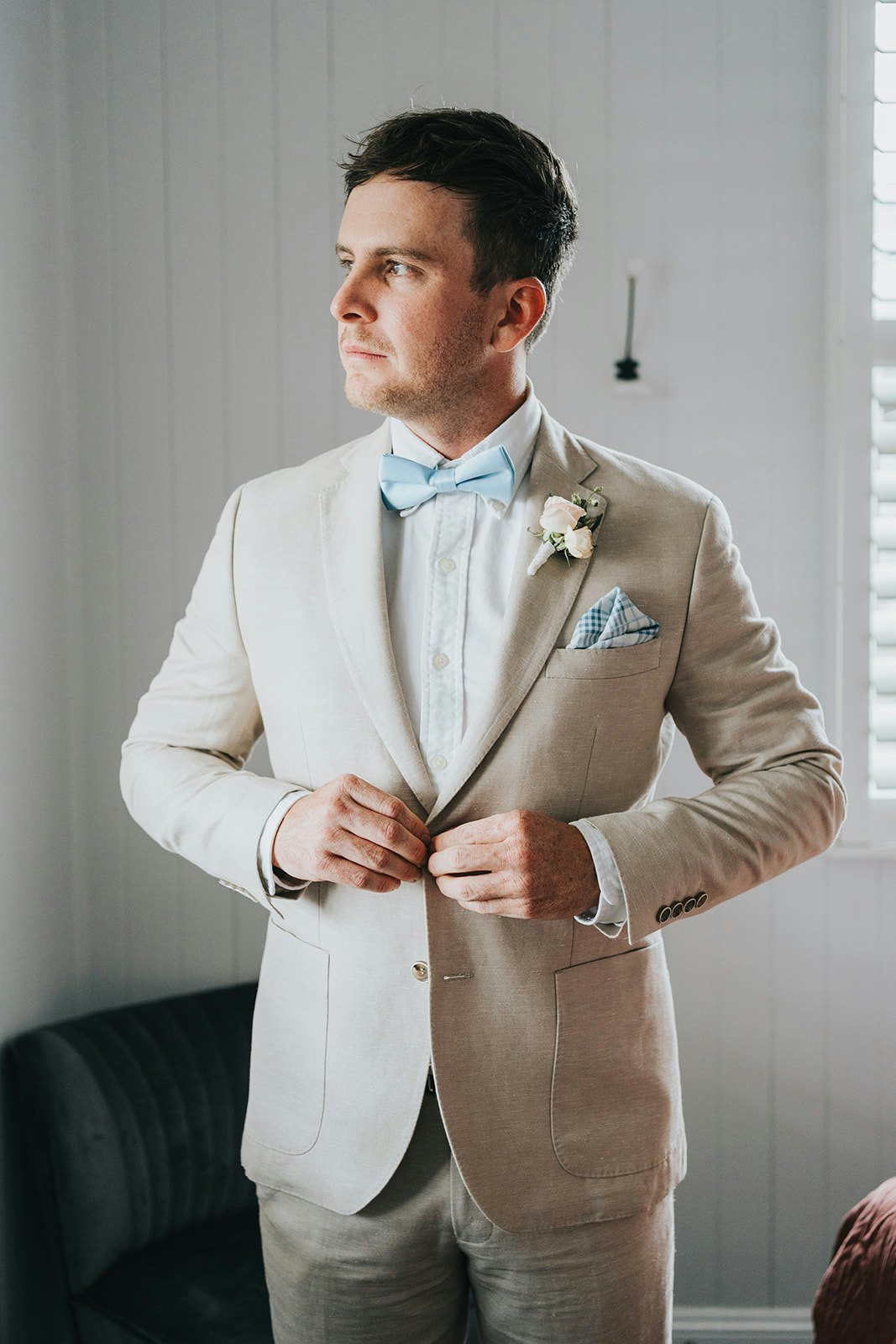 Groom buttoning up jacket