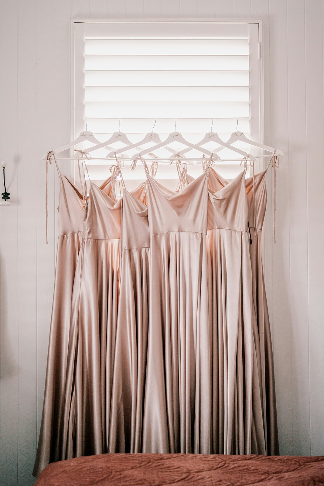 Bridesmaids dresses hanging from window