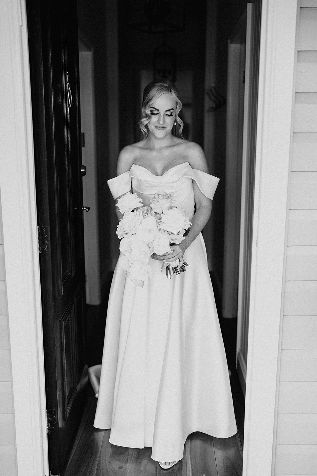 Bride standing in doorway holding flowers