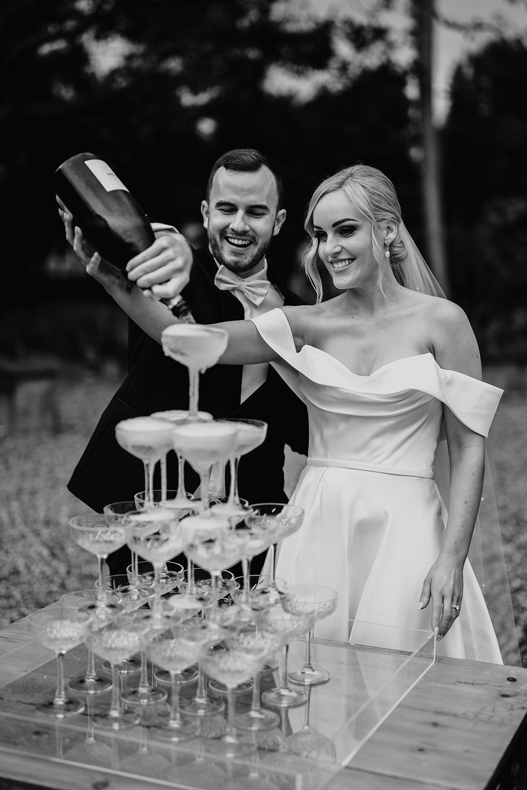 Bride and groom pouring champagne into tower