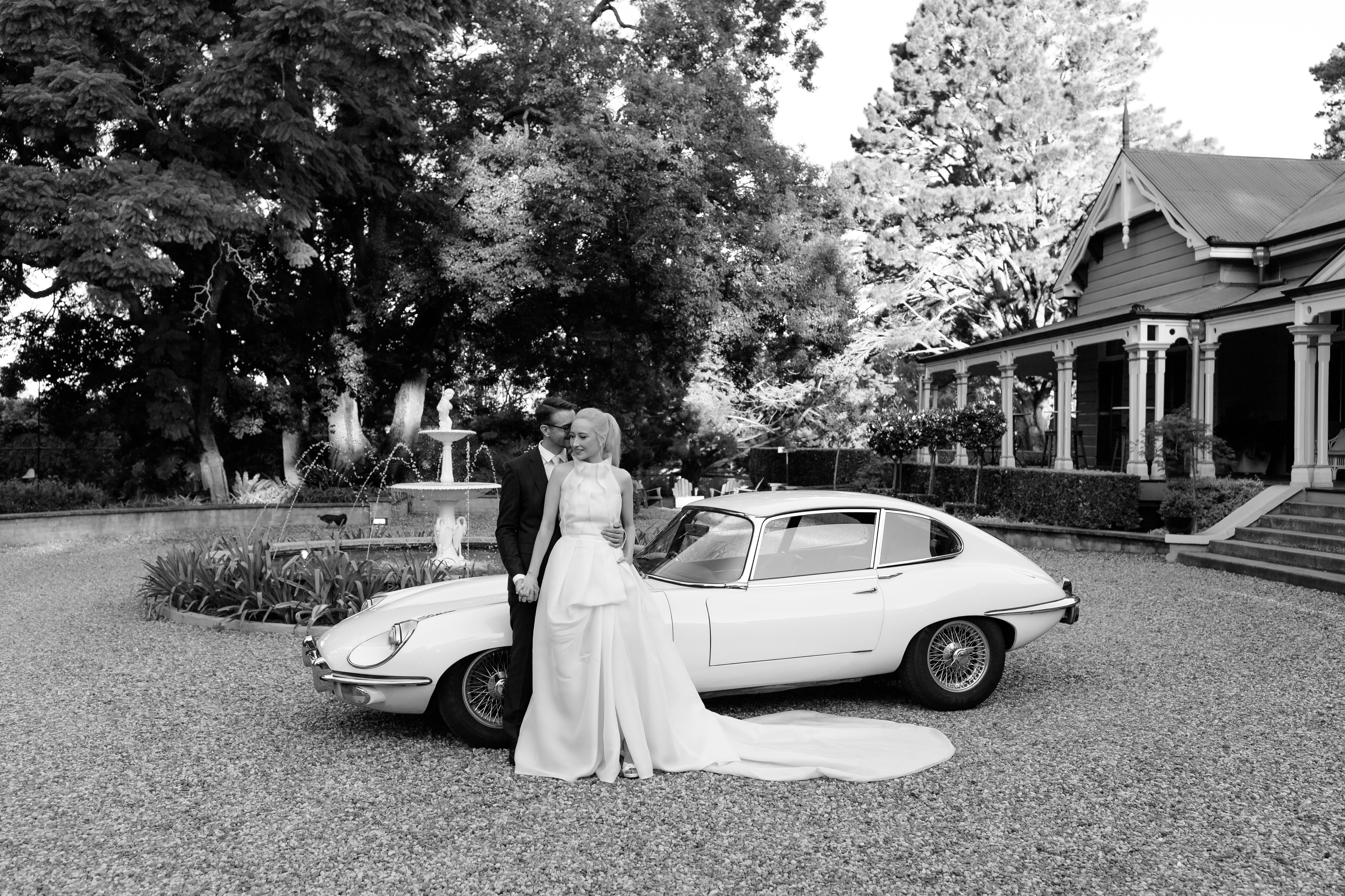 Couple pose in front of car