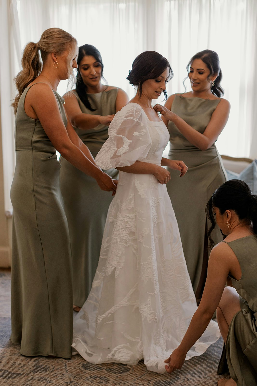 Bridesmaid getting bride dressed