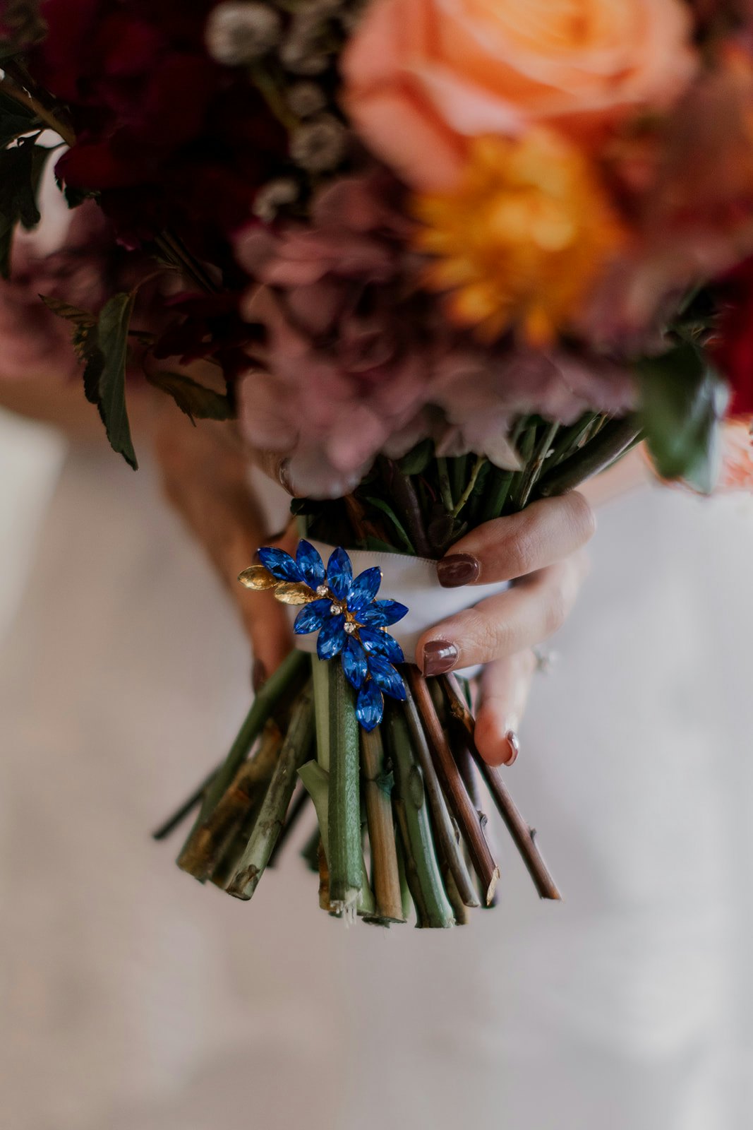 Bride holding bouquet with blue brooch