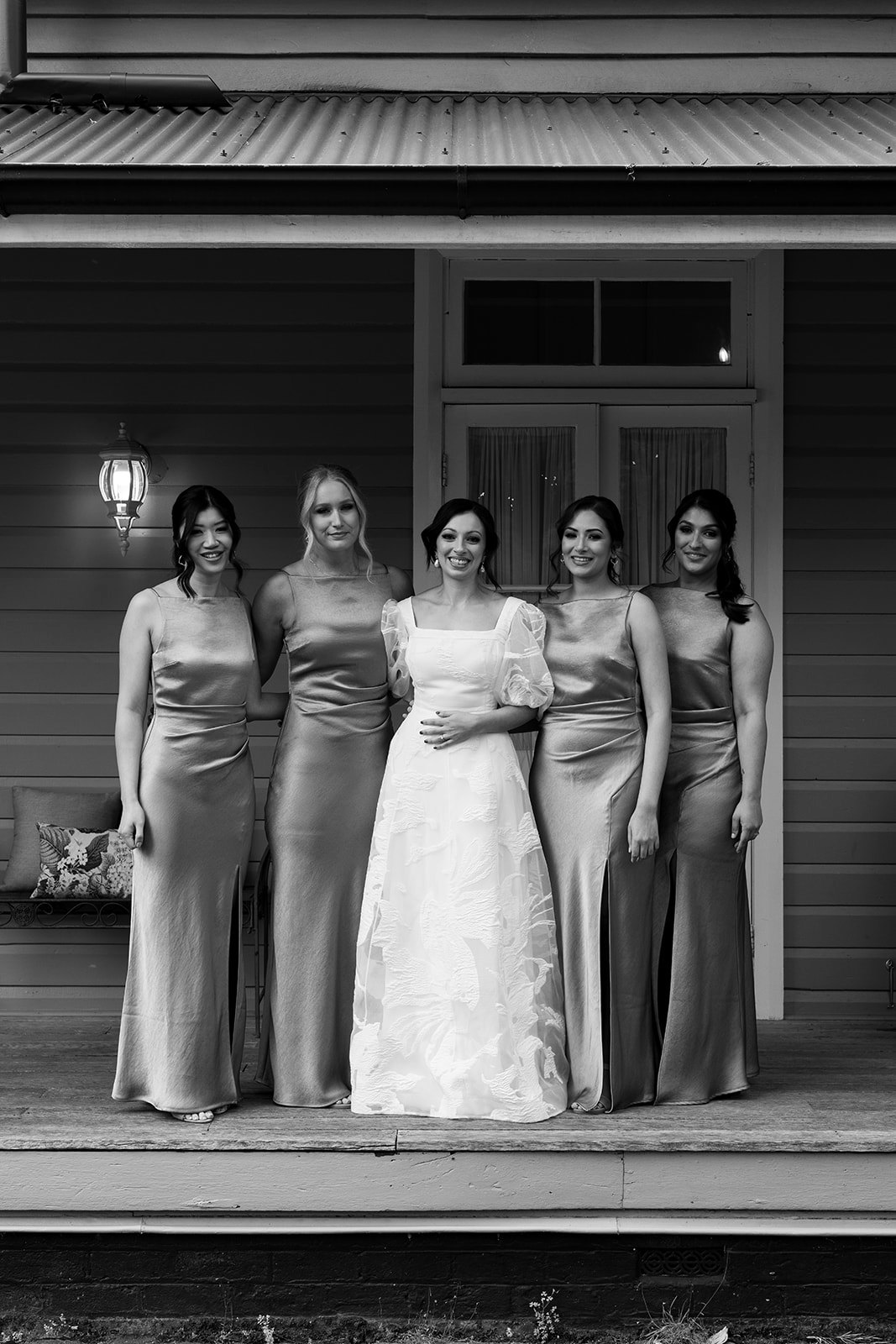 Bride and bridesmaids standing on verandah