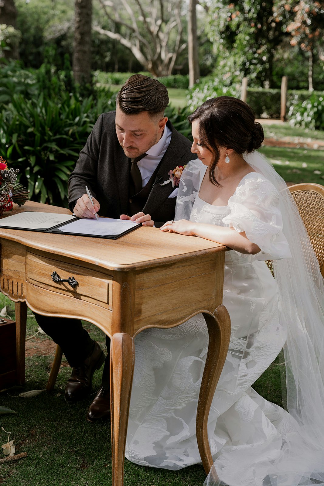 Bride and groom signing wedding certificate
