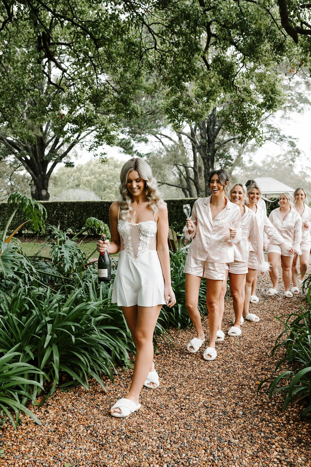Bride and bridesmaids walking in gardens