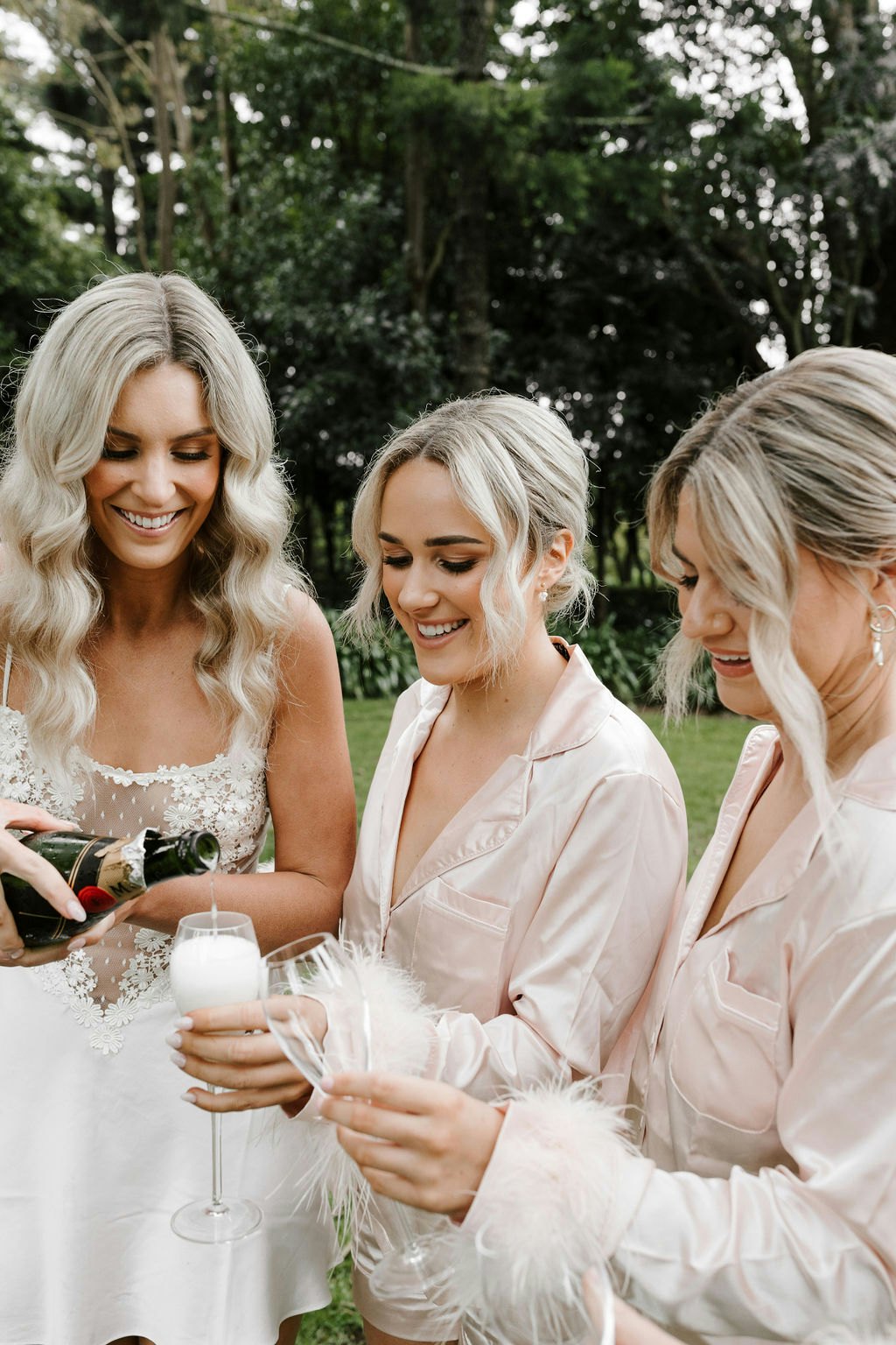 Bride pouring champagne with bridesmaids