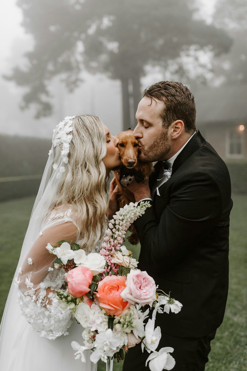 Bride and groom kissing dog