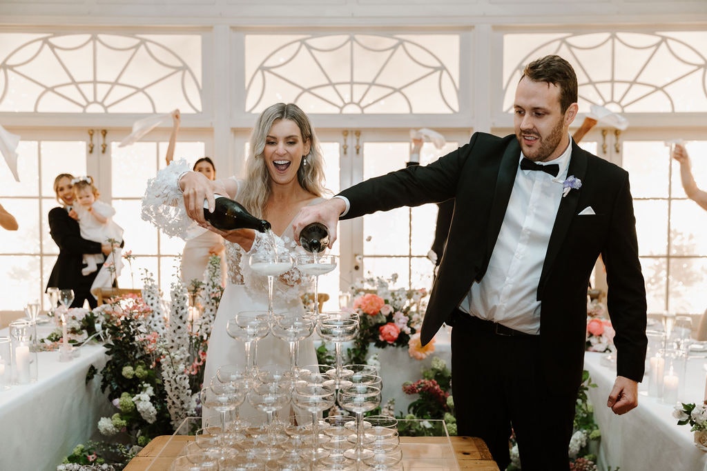 Bride and groom pouring champagne tower