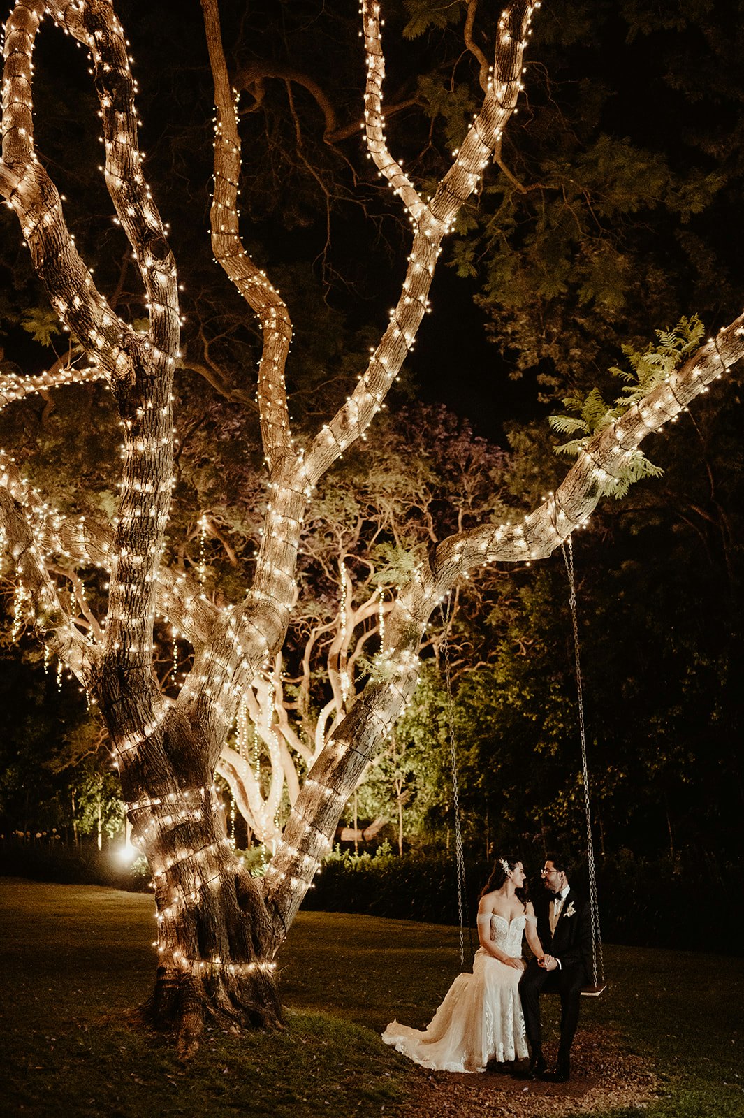 Bride and groom on swing at night