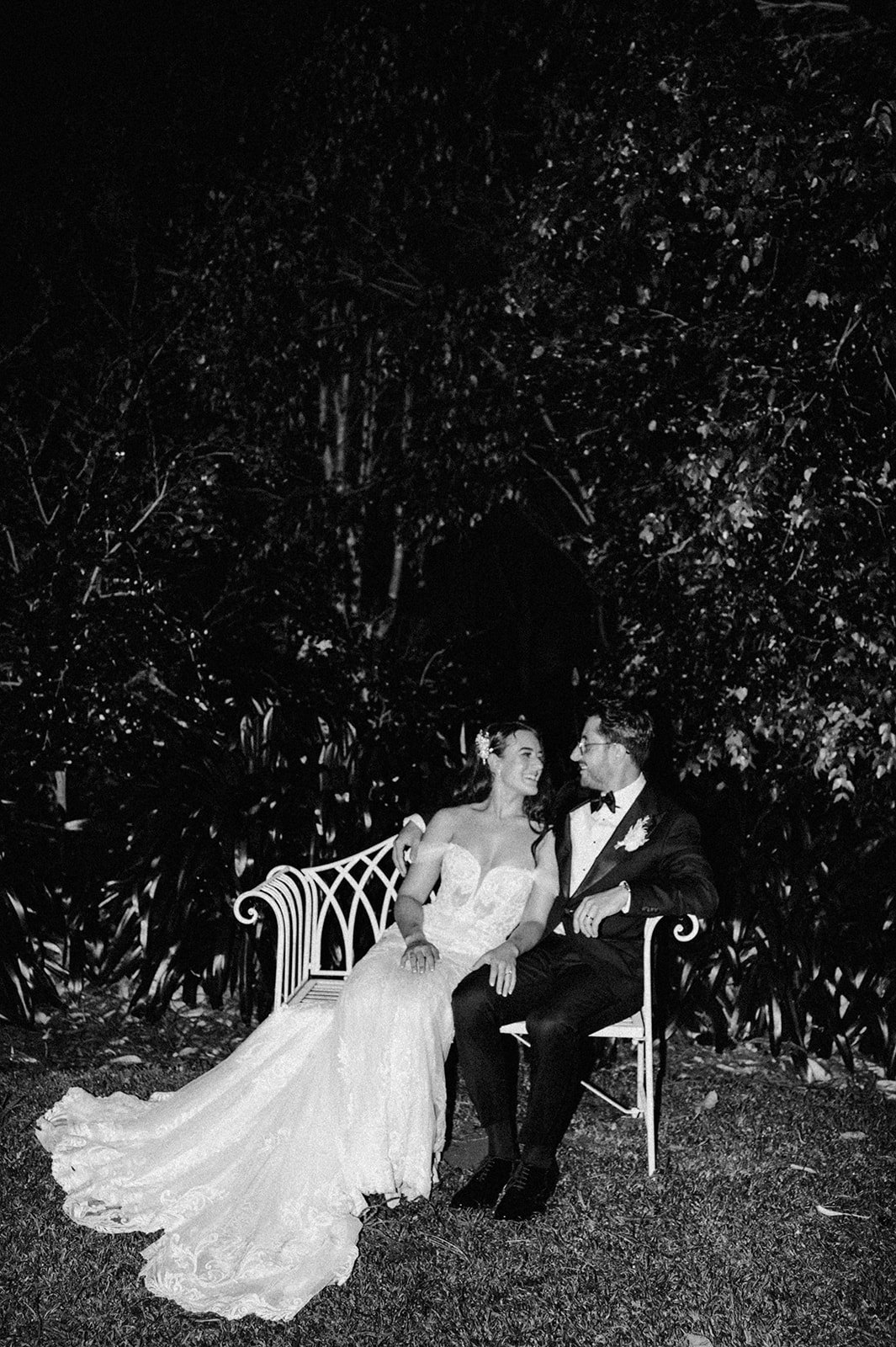 Bride and groom sitting on chair at night