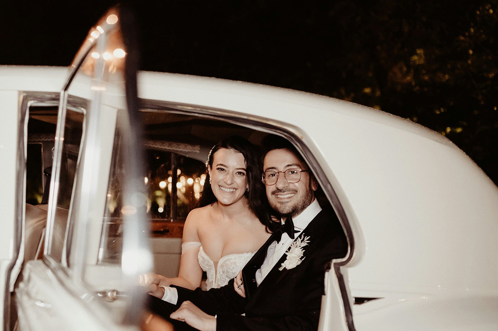 Bride and groom sitting in car