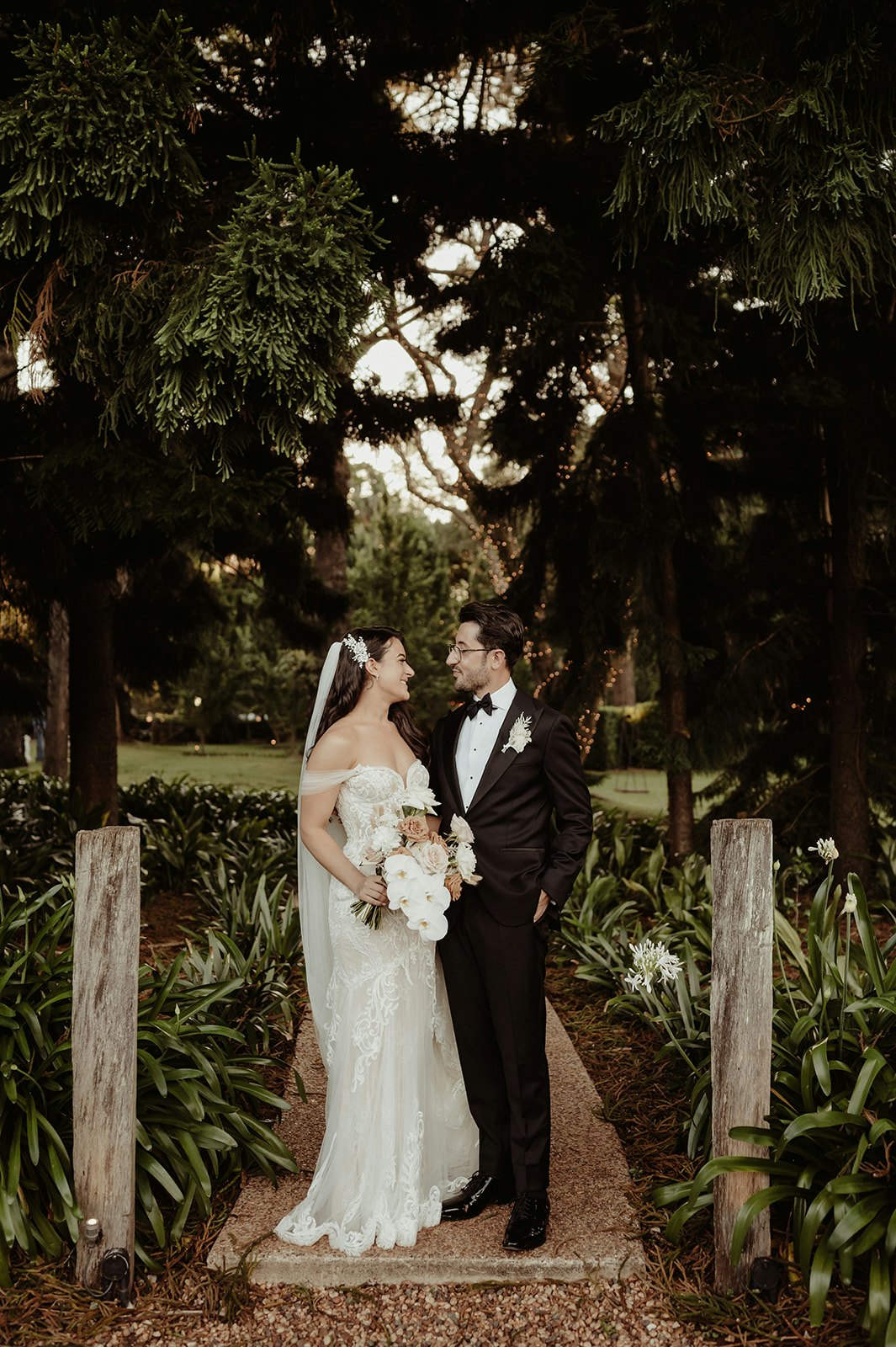 Bride and groom standing on garden path