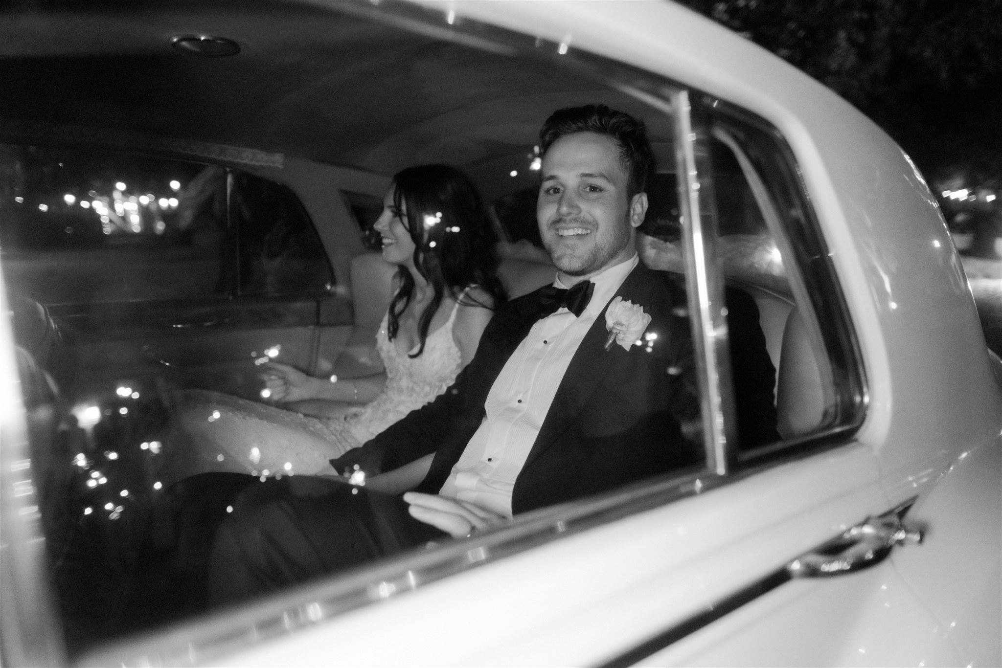 Bride and groom driving in car