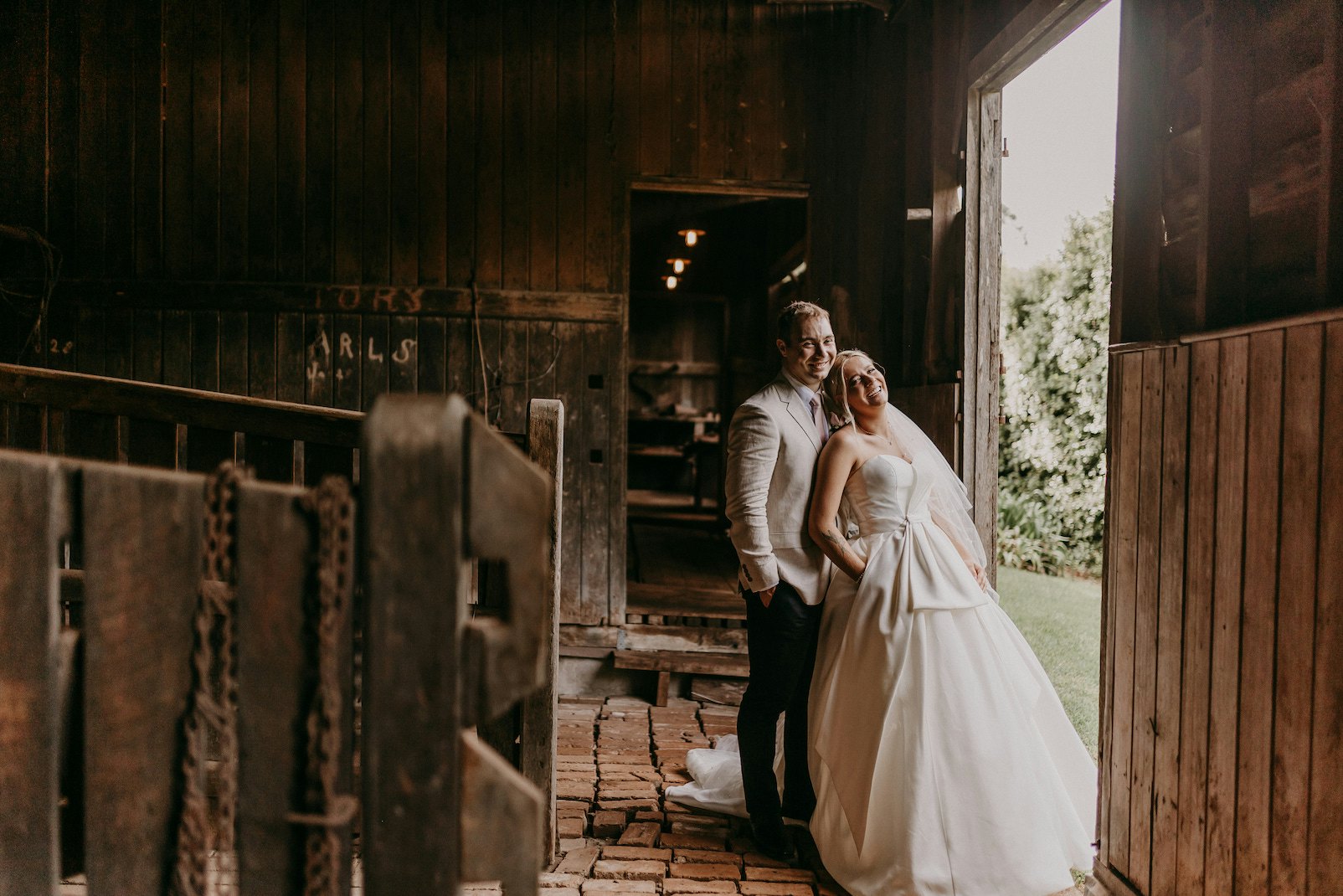 Bride and groom standing in stables