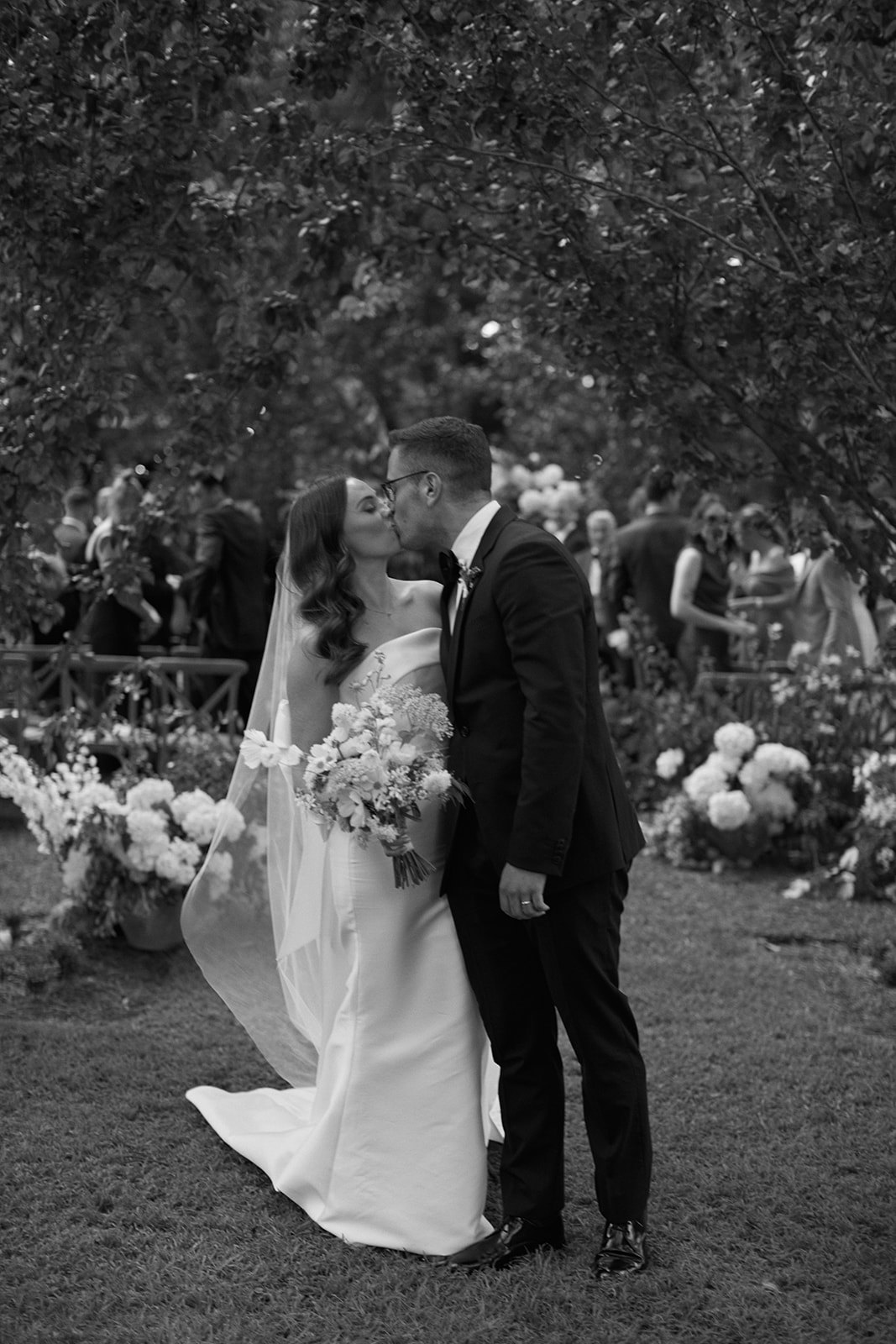 Bride and groom kissing at end of aisle