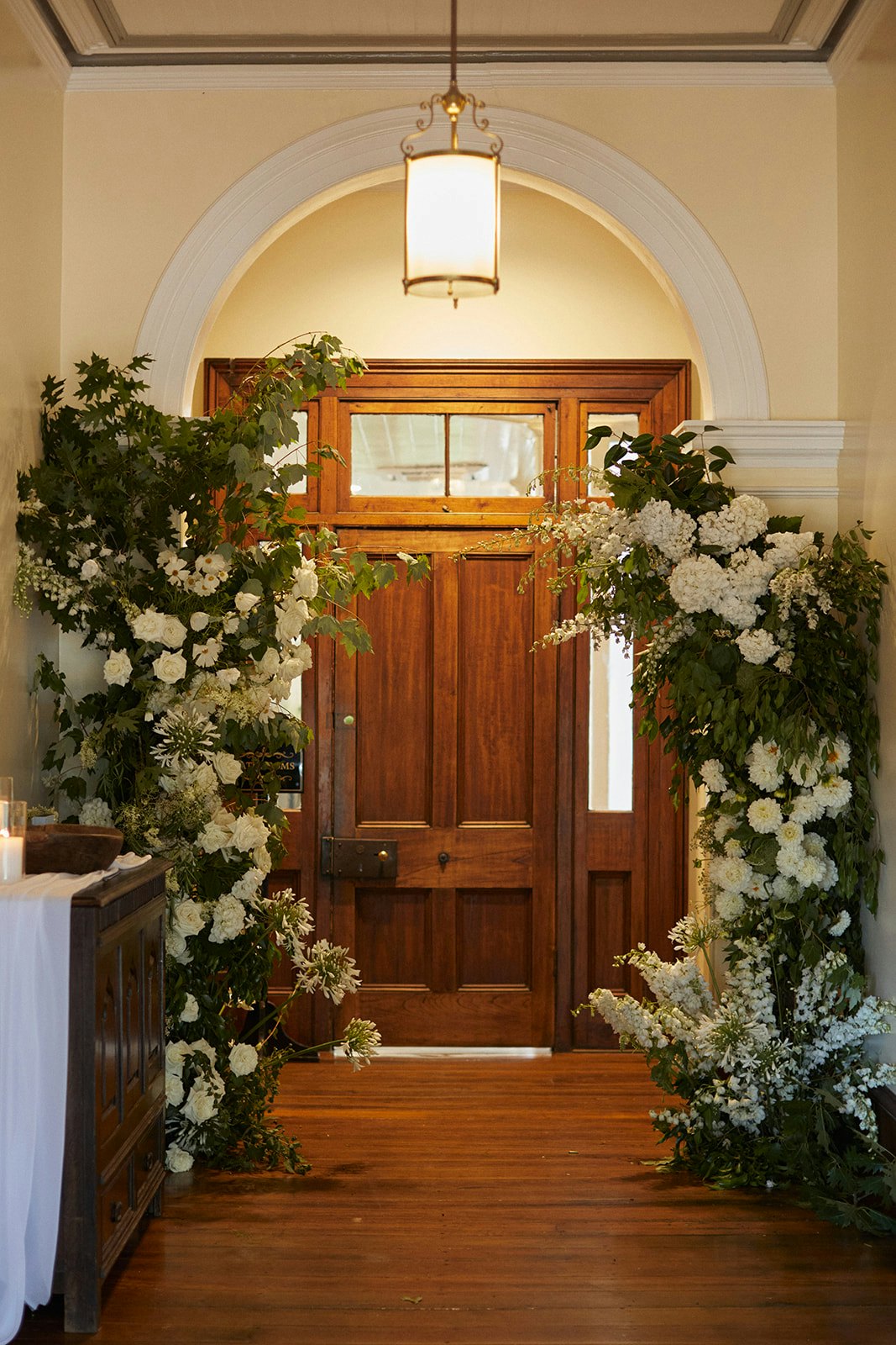 Flowers in hallway with large wooden door