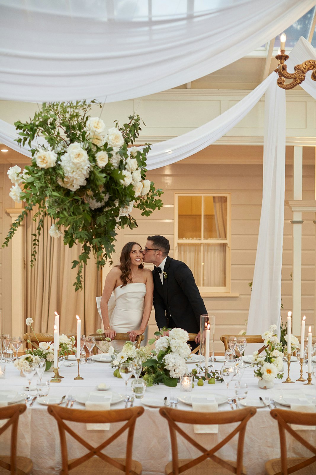 Groom kissing bride at wedding reception