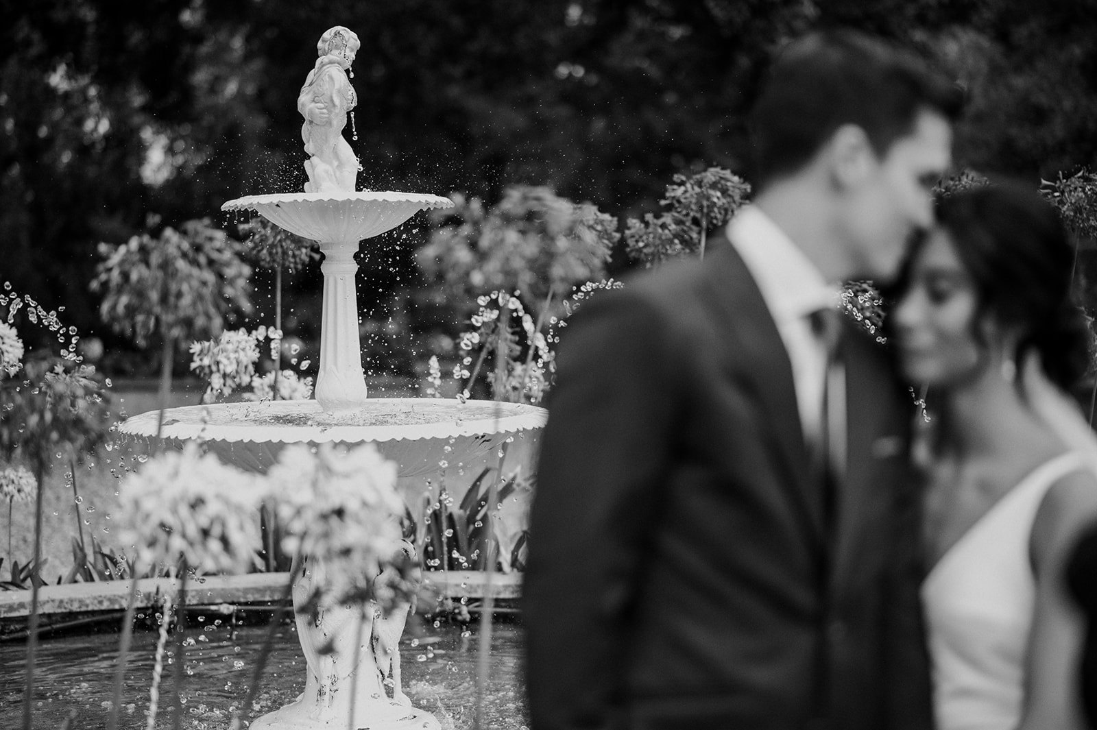 Bride and groom with fountain in background